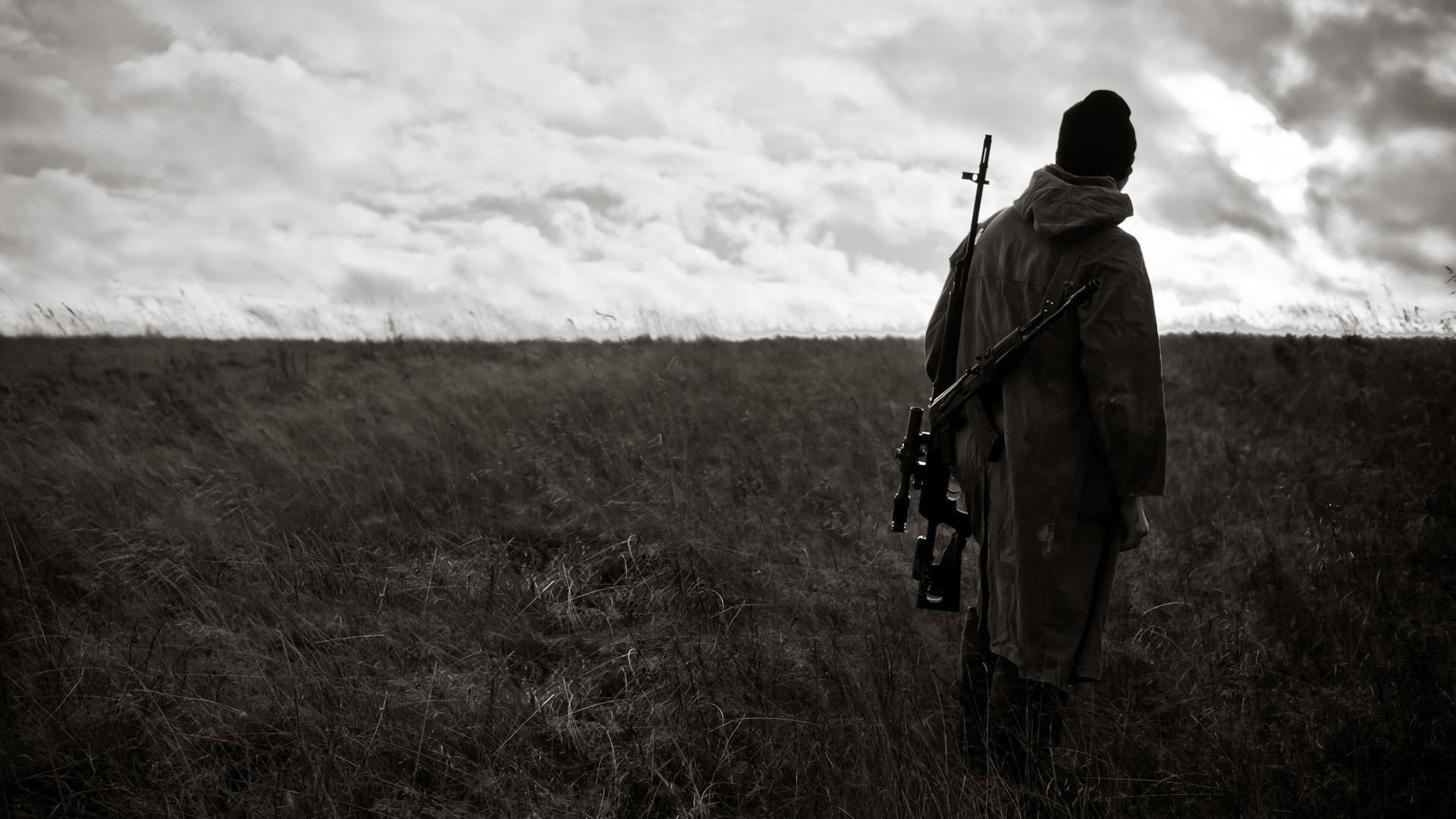 Man with sniper rifle in a field HD Wallpaper