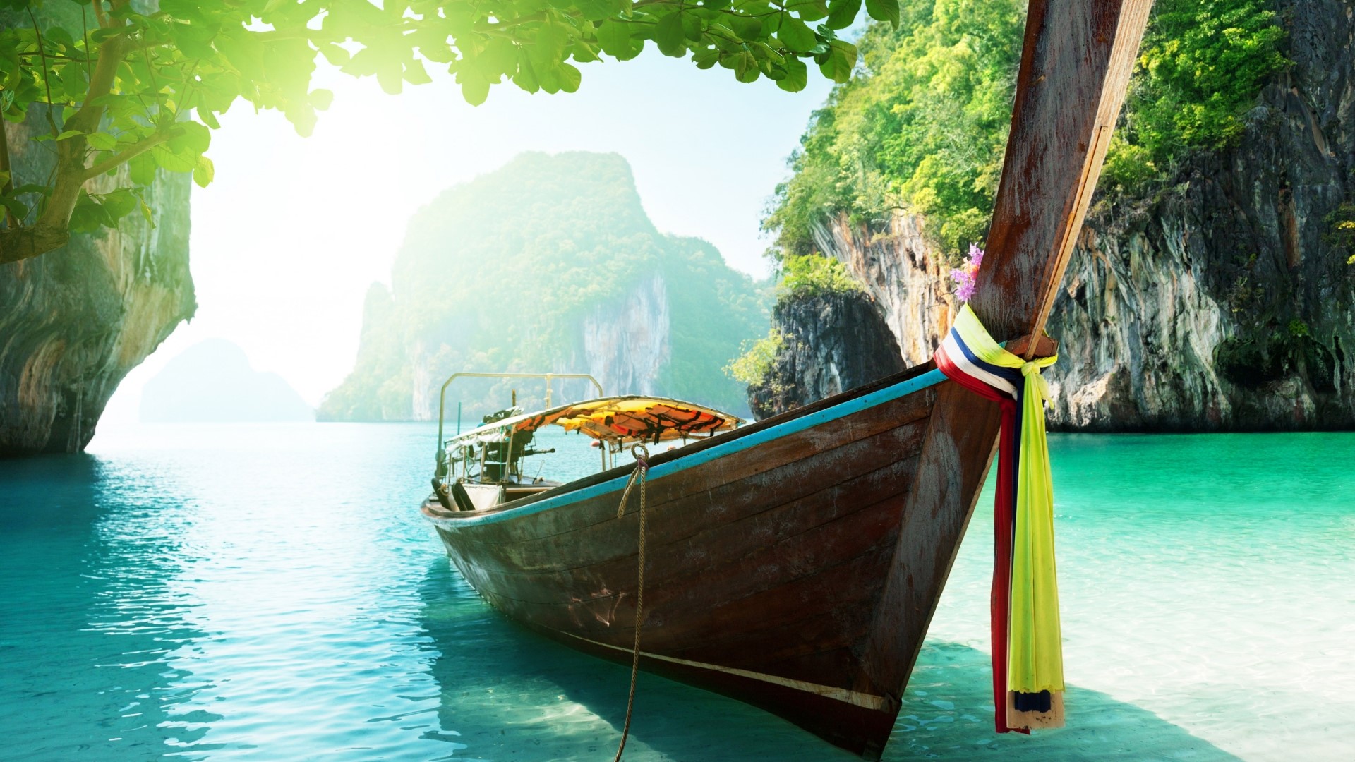Longtail boat in a tropical bay with limestone cliffs HD Wallpaper