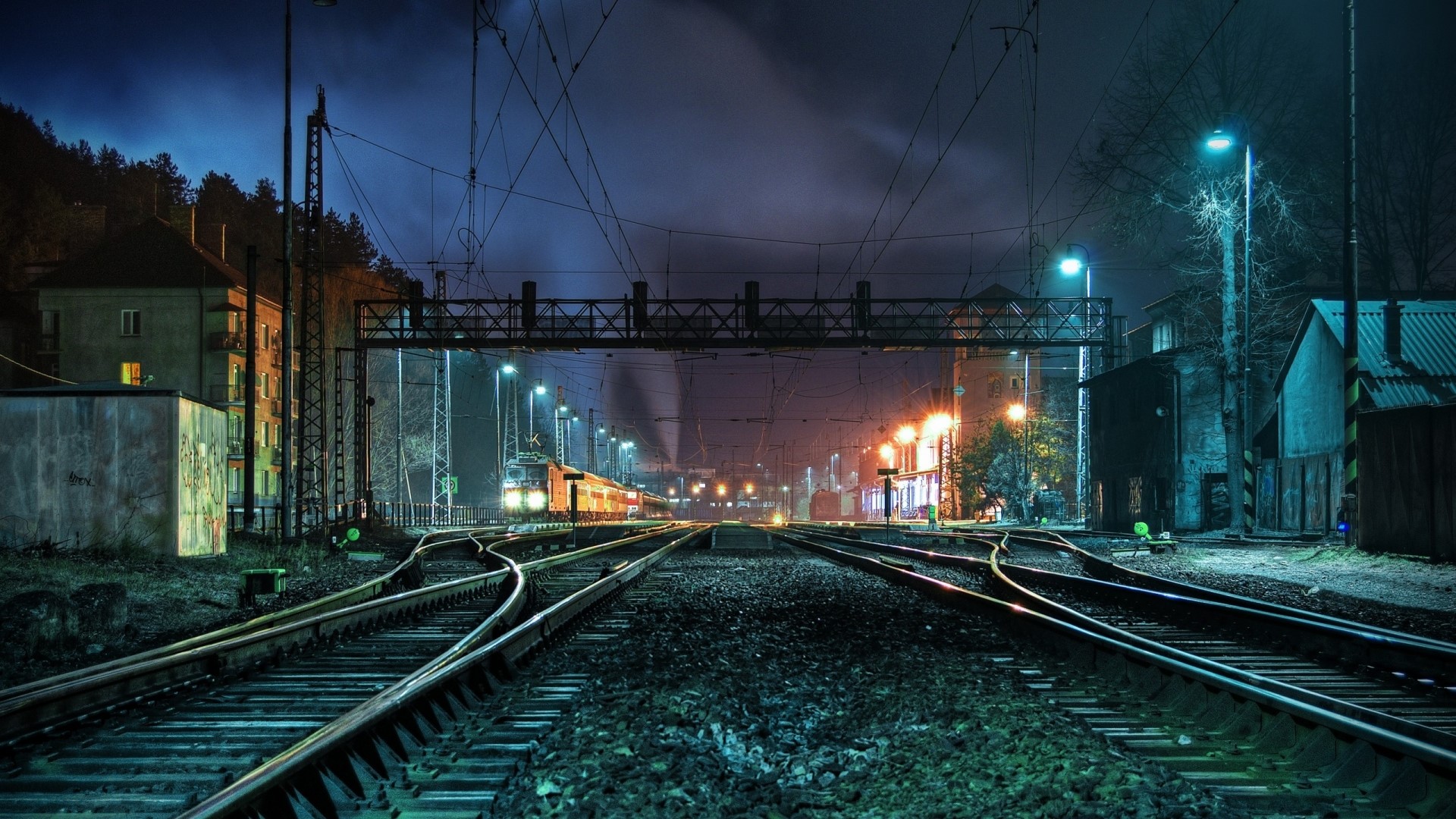 Train tracks at night in a city HD Wallpaper