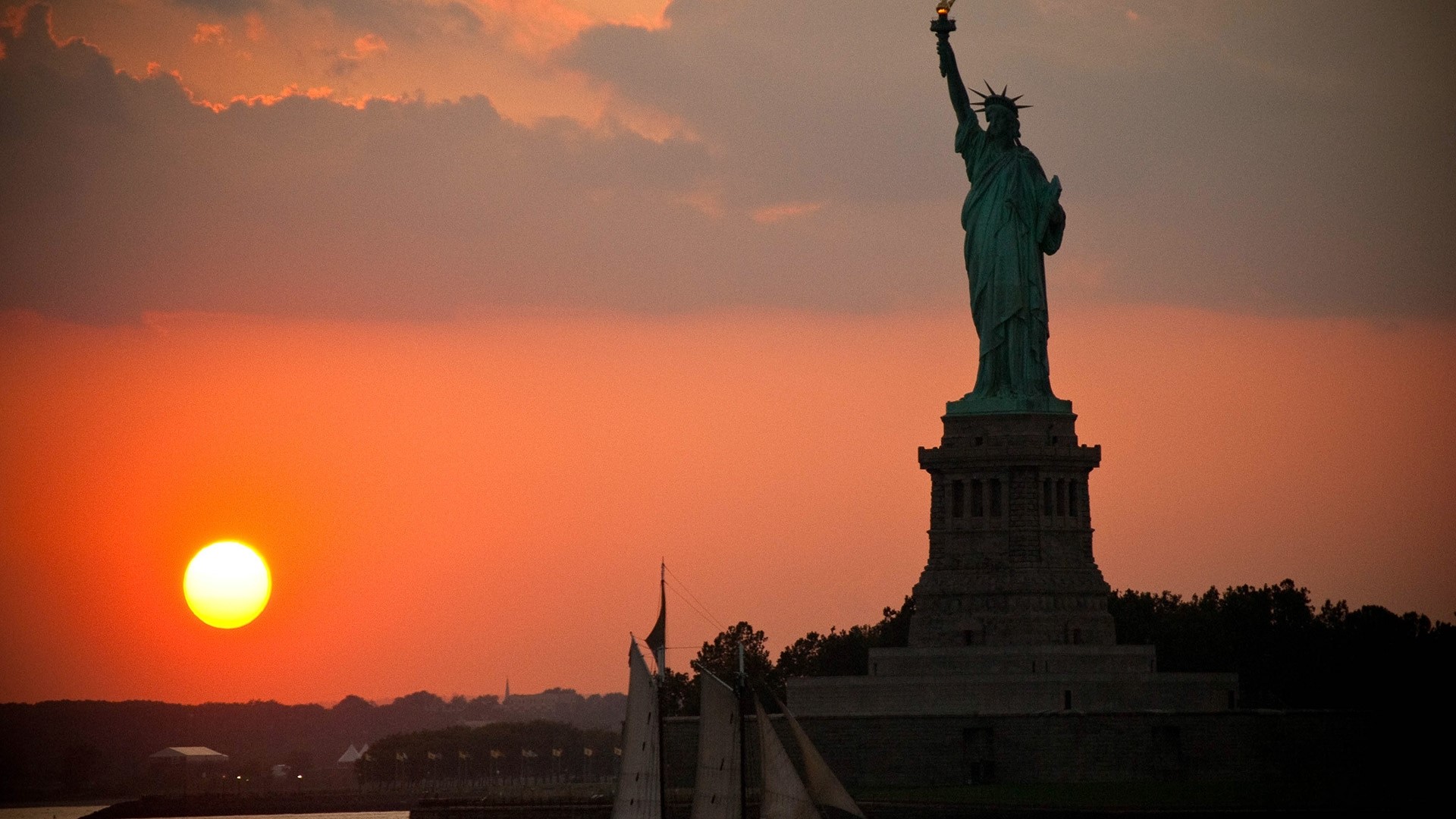 Statue of Liberty at sunset with sailboats HD Wallpaper