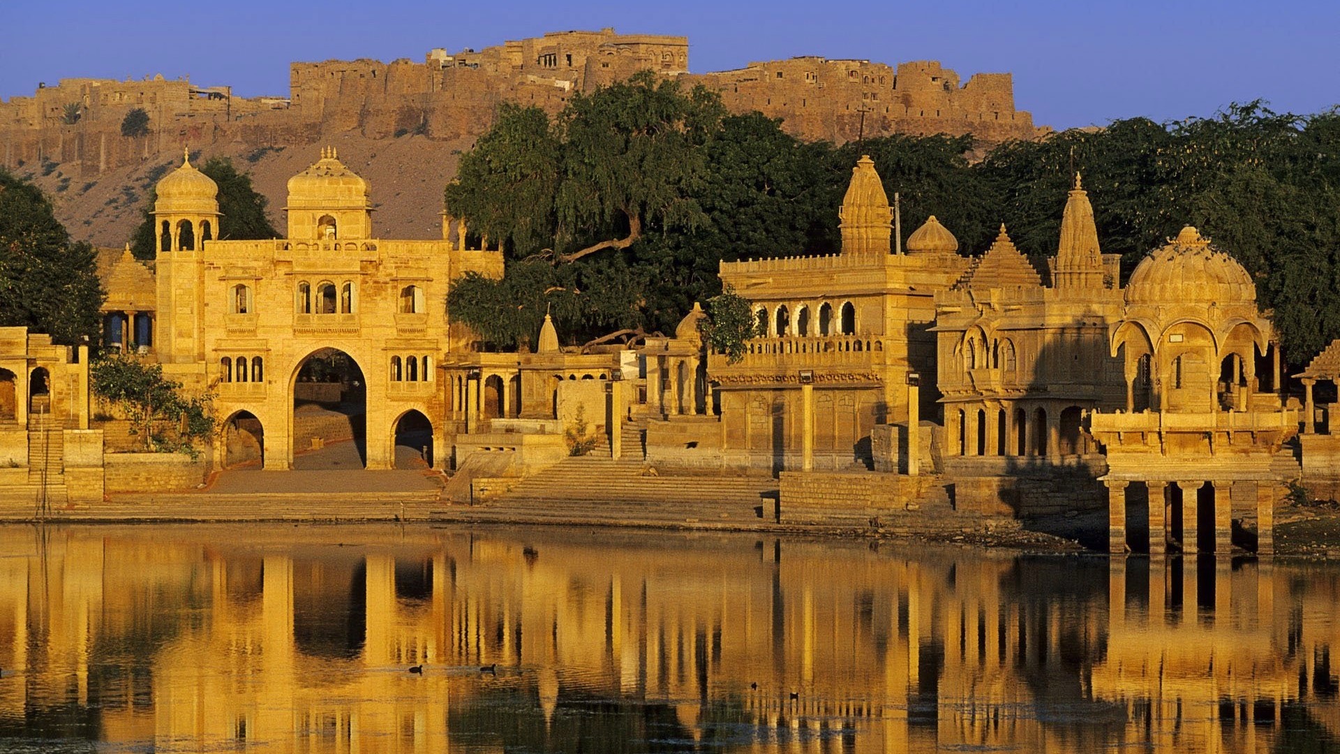 Golden fort and temples reflected in water HD Wallpaper