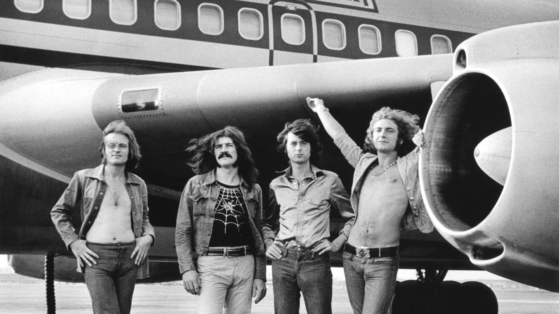 Led Zeppelin standing in front of an airplane HD Wallpaper
