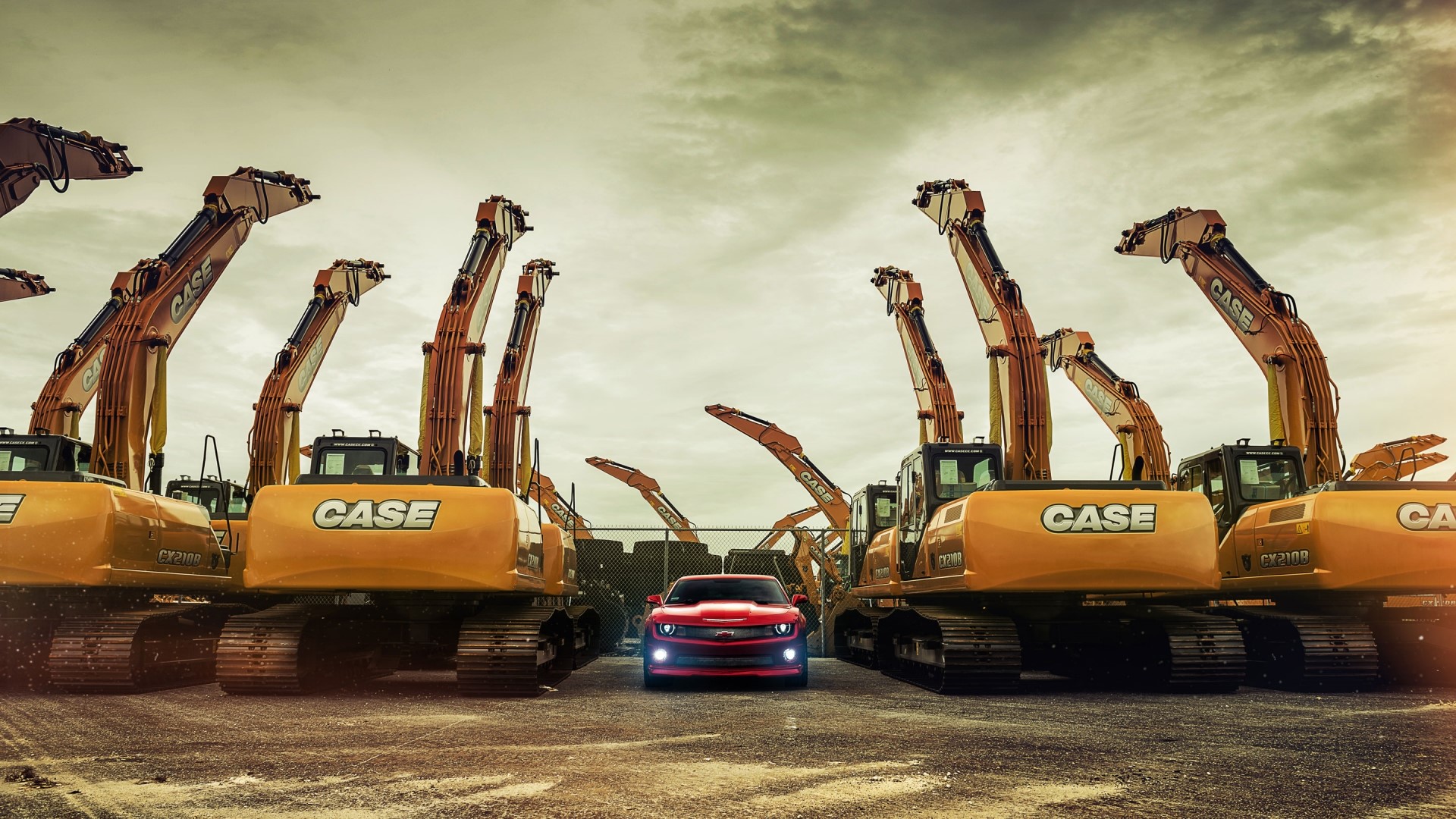 Red Chevrolet Camaro parked between Case excavators HD Wallpaper