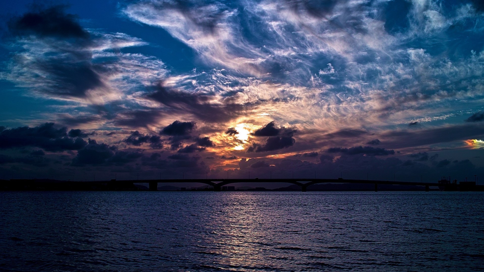 Sunset over water with bridge and clouds HD Wallpaper