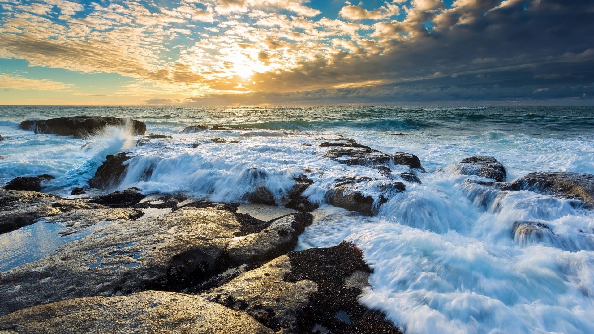 Waves crashing on rocky shore at sunset HD Wallpaper