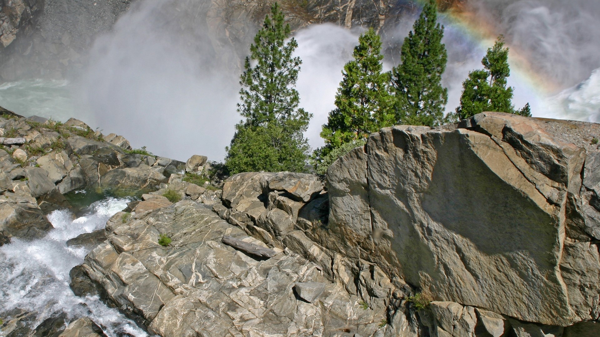Rainbow over a waterfall and rocky cliff HD Wallpaper