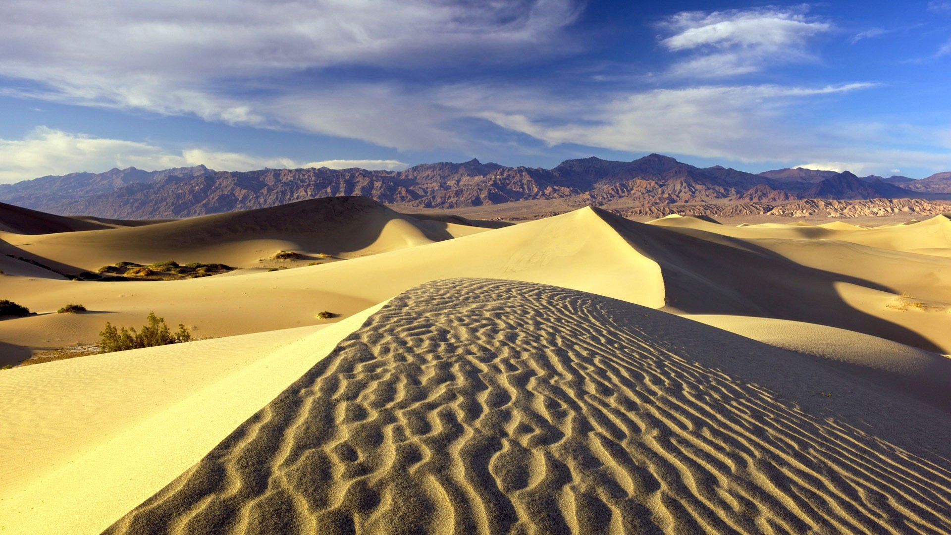 Sand dunes and mountains under a blue sky HD Wallpaper