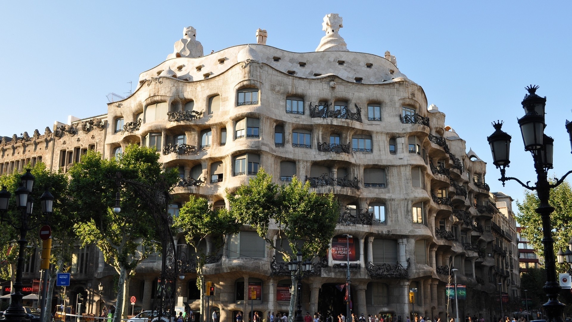 La Pedrera building with trees and street lamps HD Wallpaper