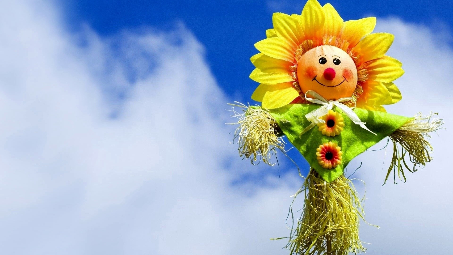 Scarecrow with sunflower head against blue sky HD Wallpaper