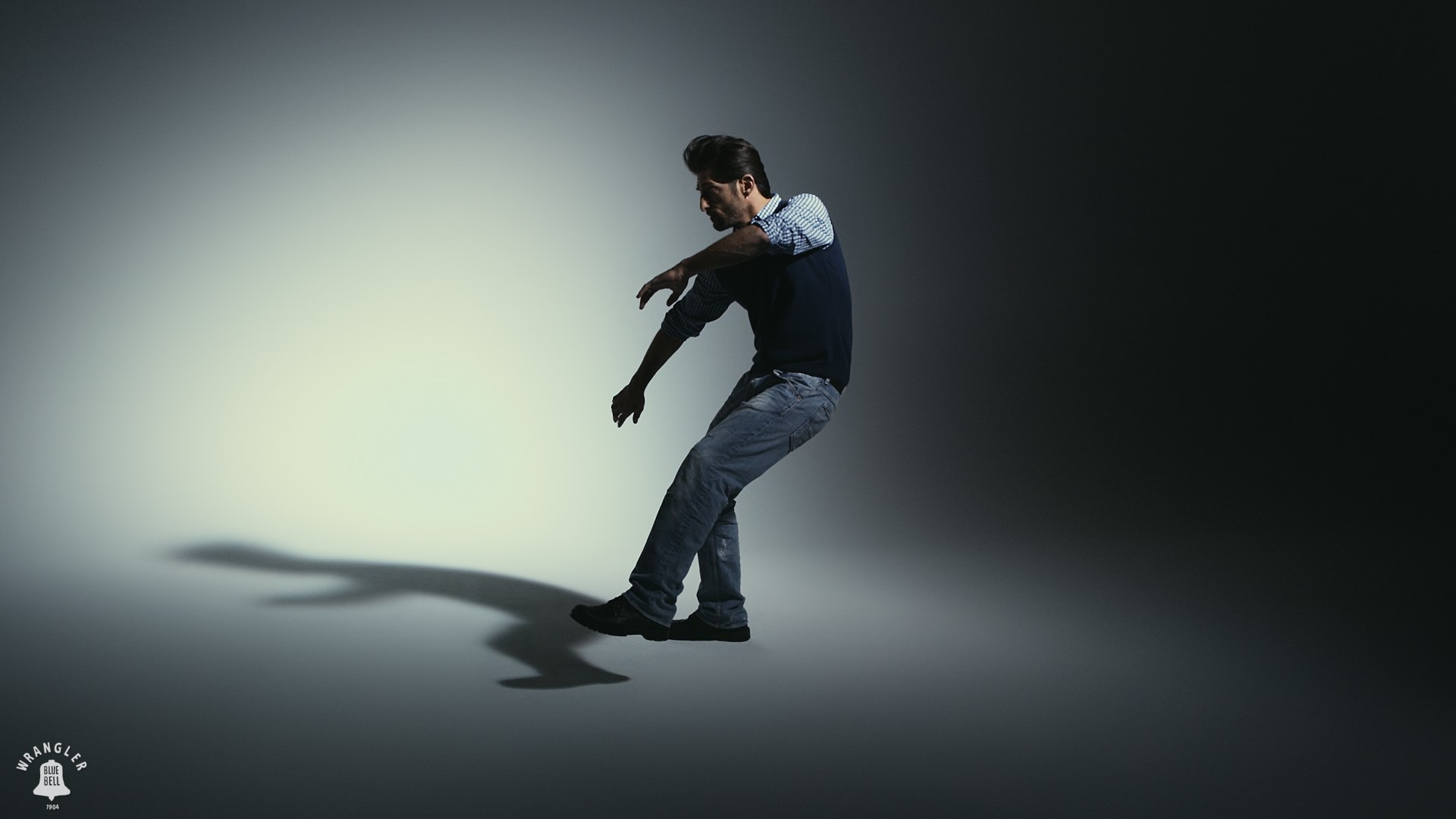 Man in jeans and sweater posing in studio HD Wallpaper