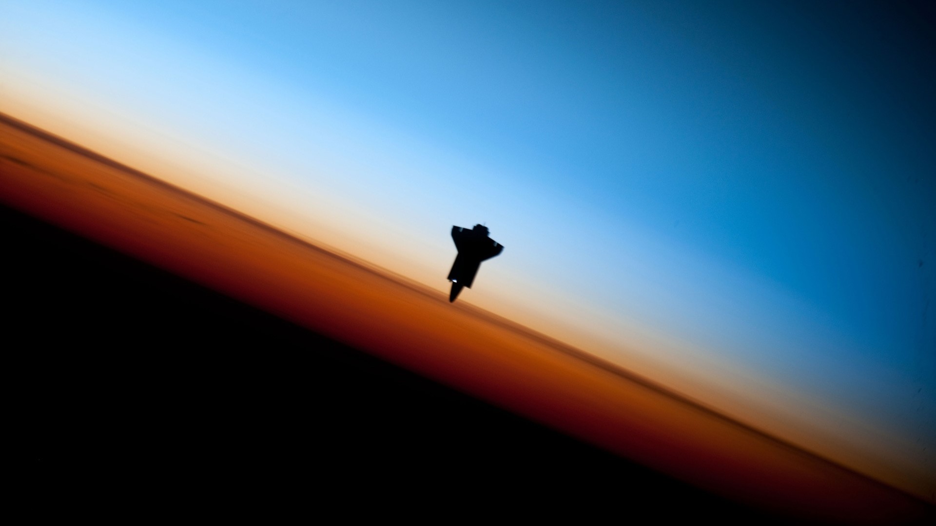 Space Shuttle Endeavour silhouette against Earth's atmosphere HD Wallpaper
