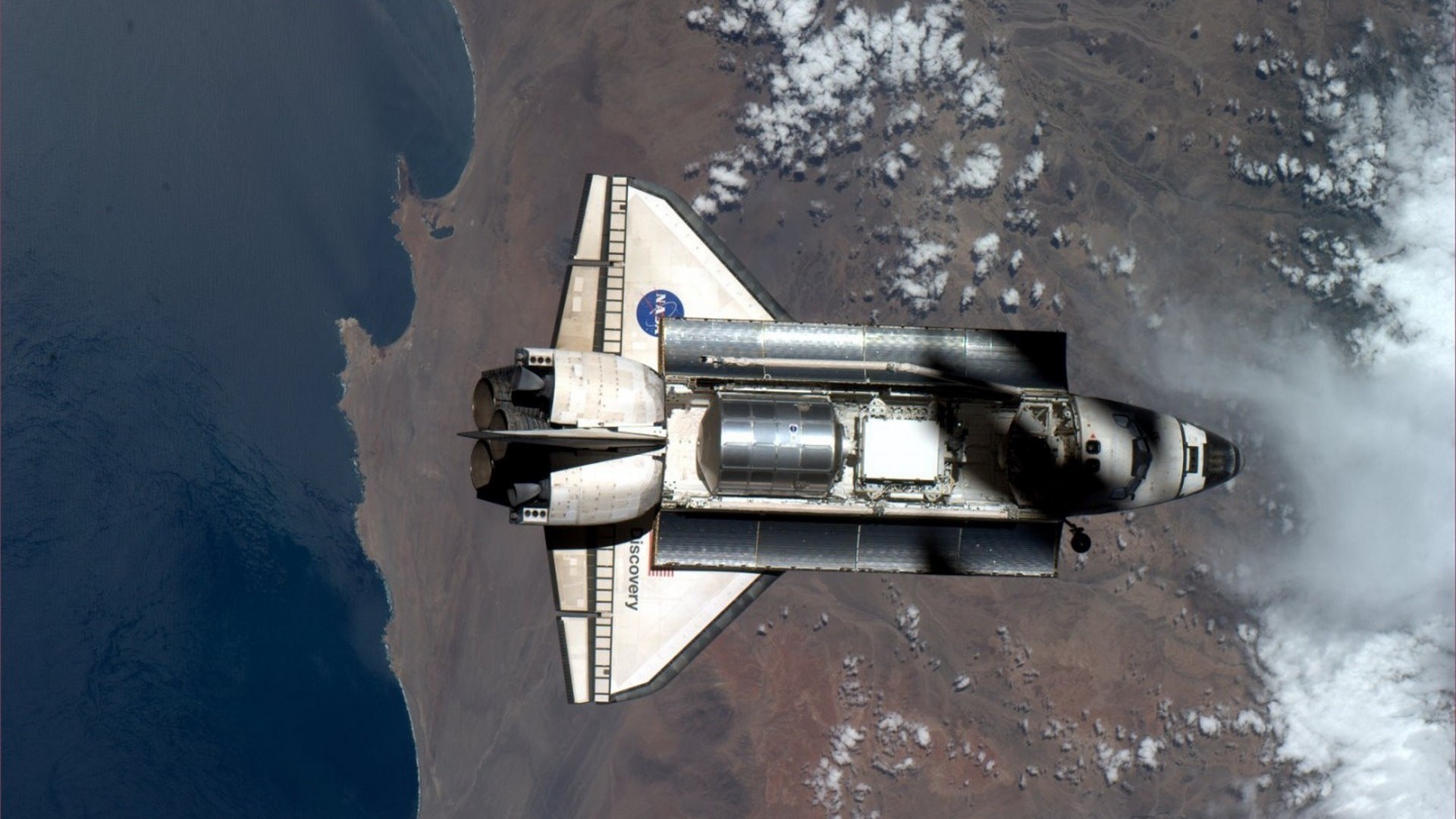 Space Shuttle Discovery in orbit over Earth HD Wallpaper