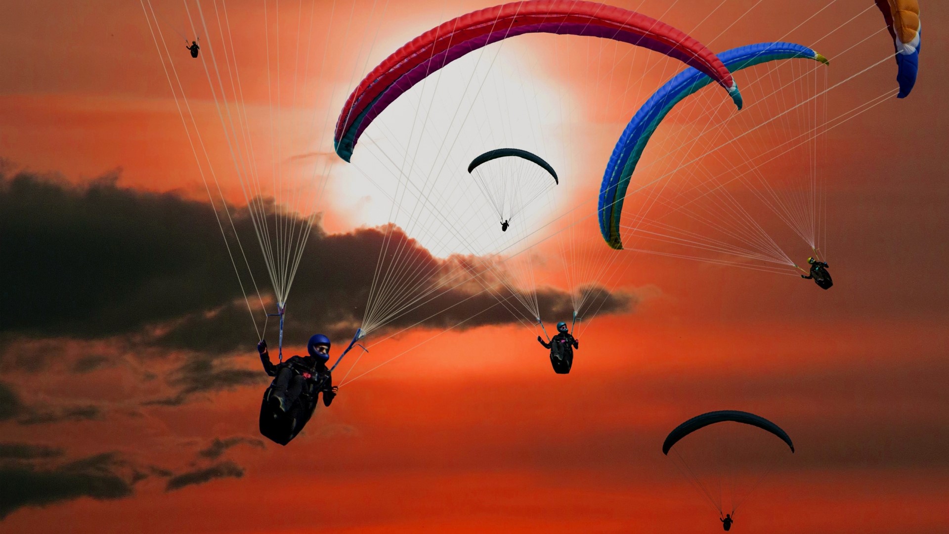 Paragliders flying against a sunset sky HD Wallpaper