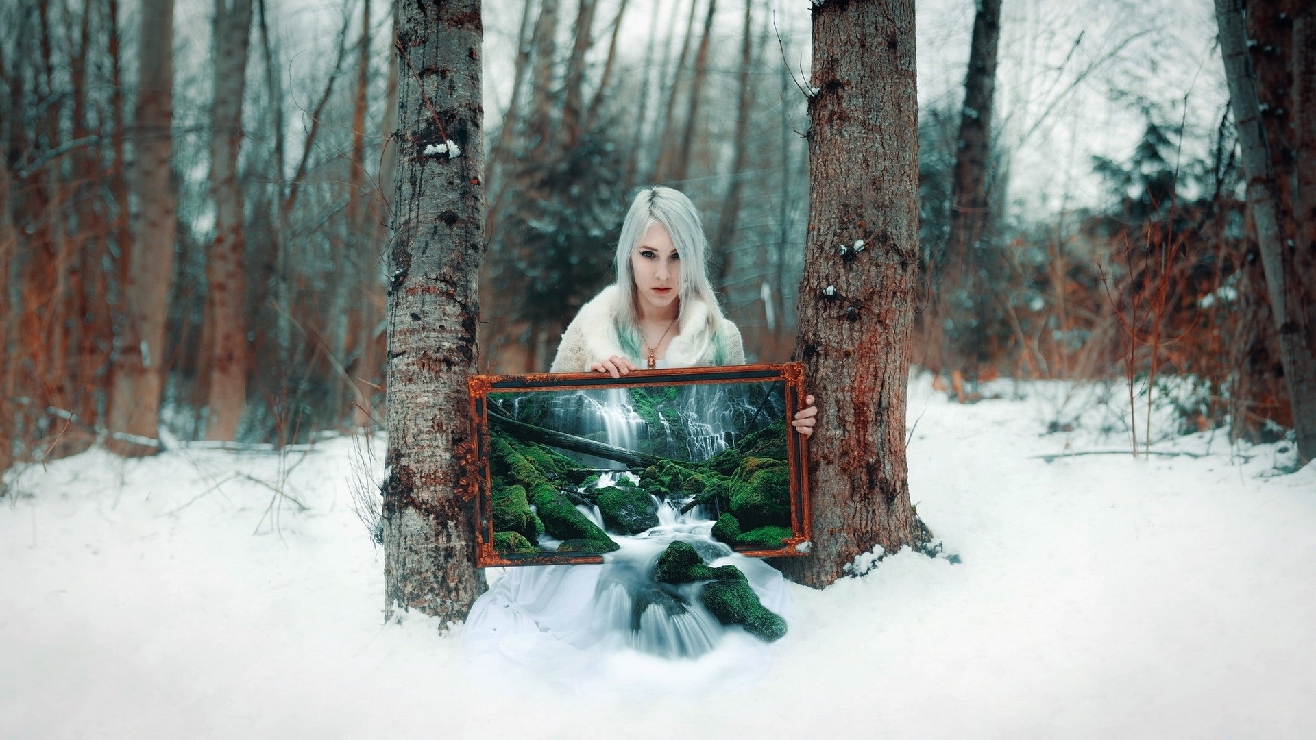 Woman holding a painting of a waterfall in a snowy forest HD Wallpaper