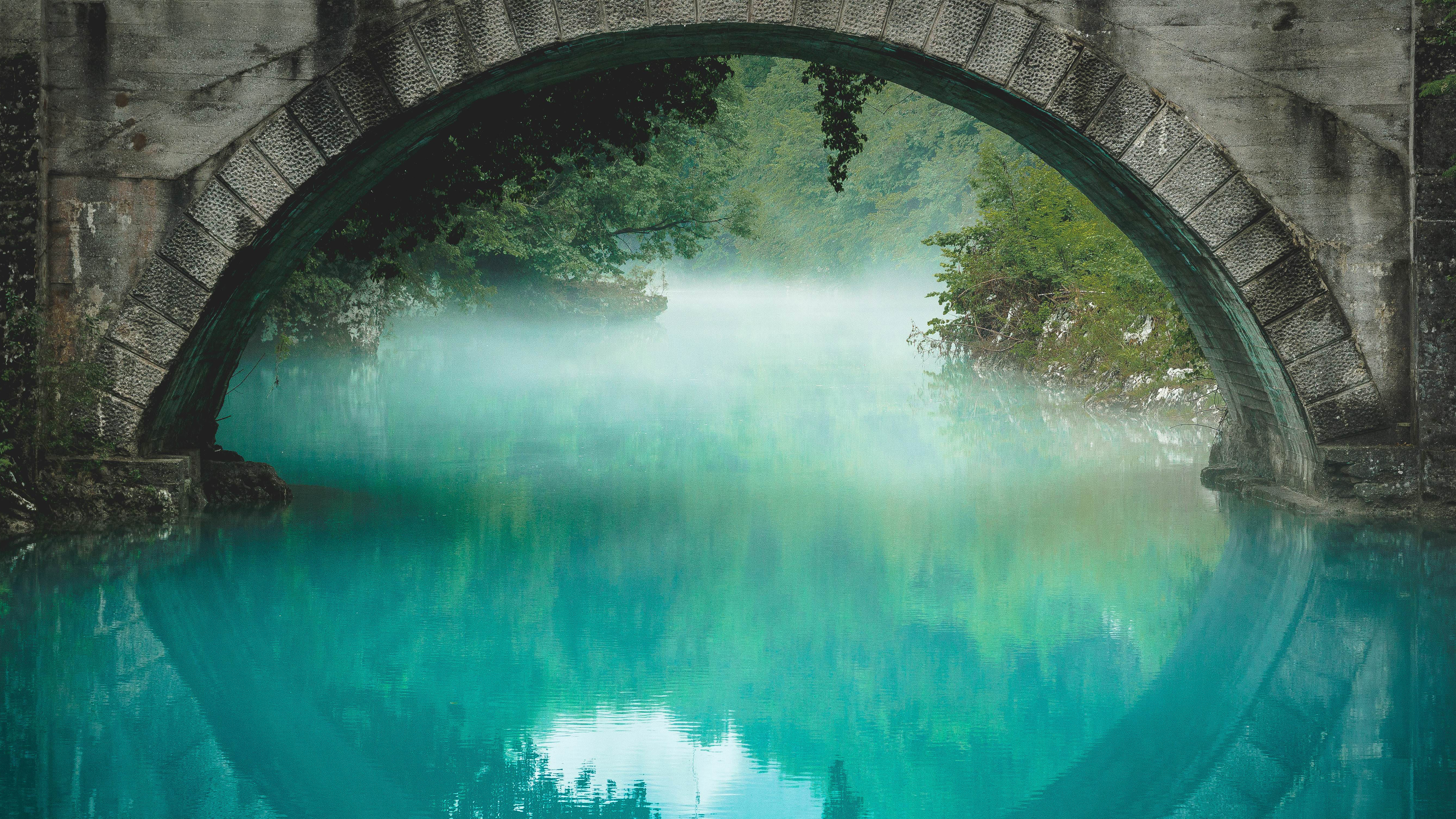 Stone bridge over turquoise water with mist HD Wallpaper