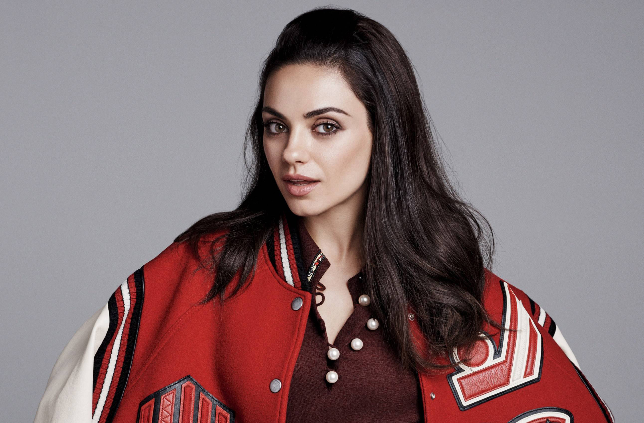 Mila Kunis in a red varsity jacket HD Wallpaper