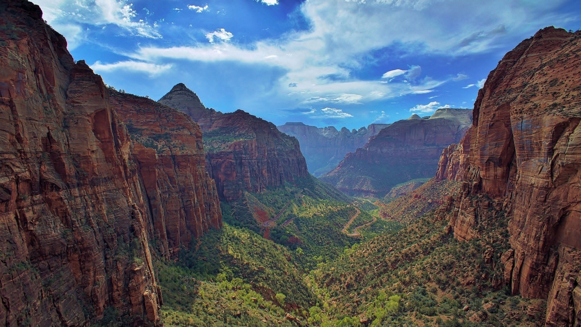 Deep Canyon Valley with Red Rock Cliffs and Green Vegetation HD Wallpaper