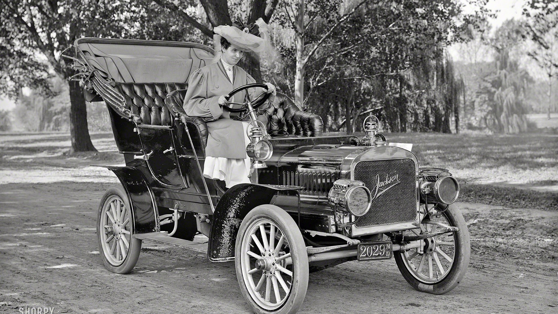 Woman in hat driving a Jackson car HD Wallpaper
