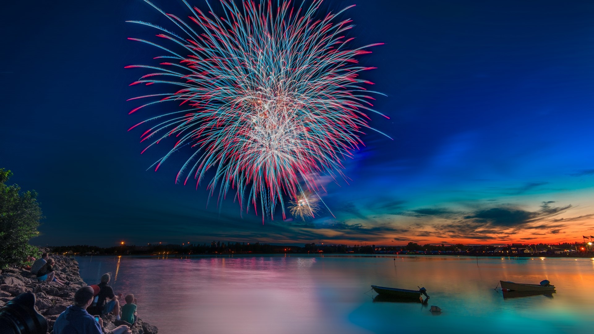 Fireworks Celebration Over Water at Dusk HD Wallpaper