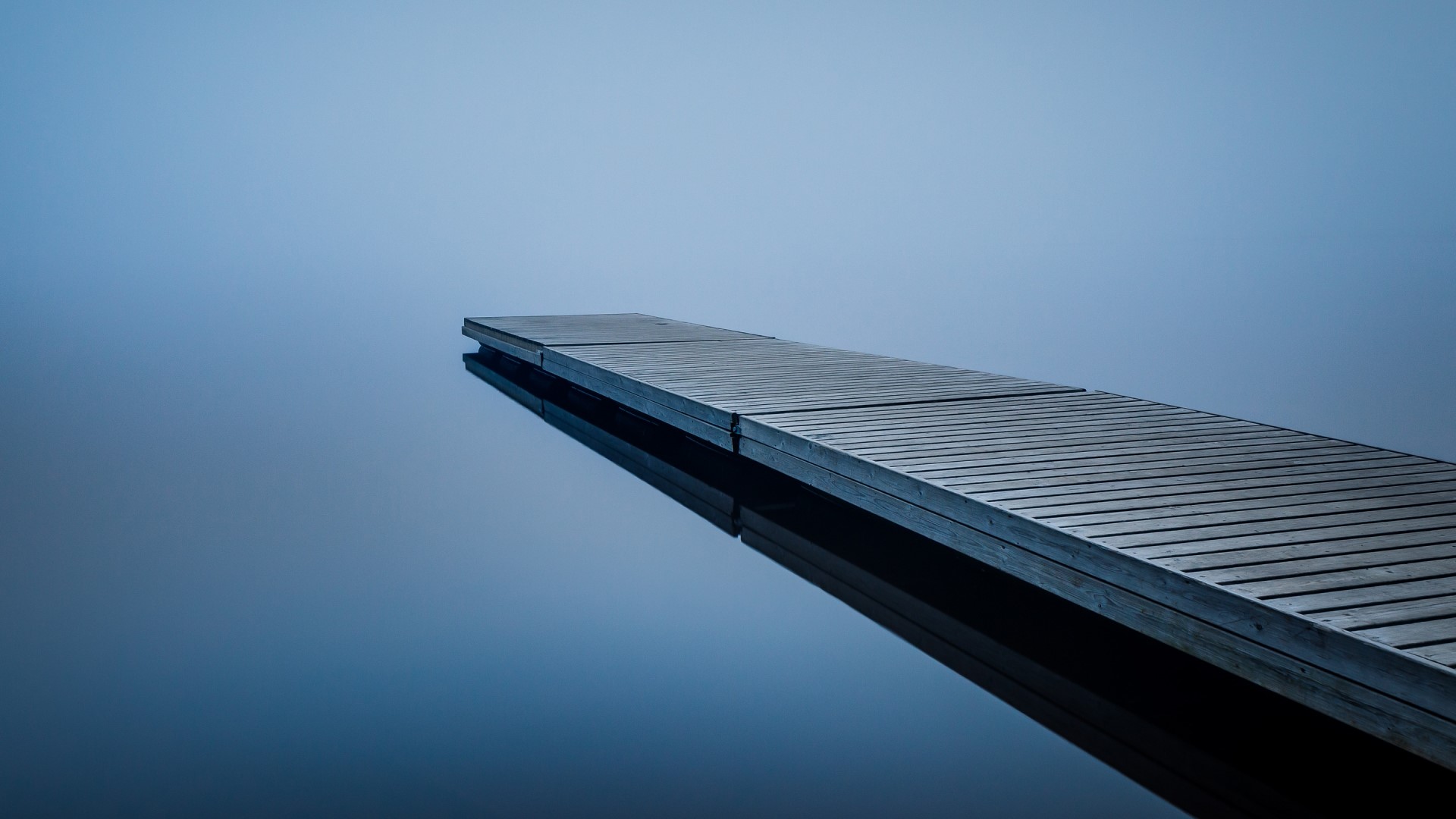 Wooden pier extending into foggy water HD Wallpaper