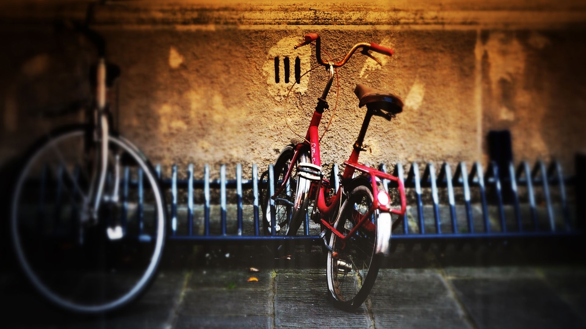 Two bicycles parked in front of a textured wall HD Wallpaper