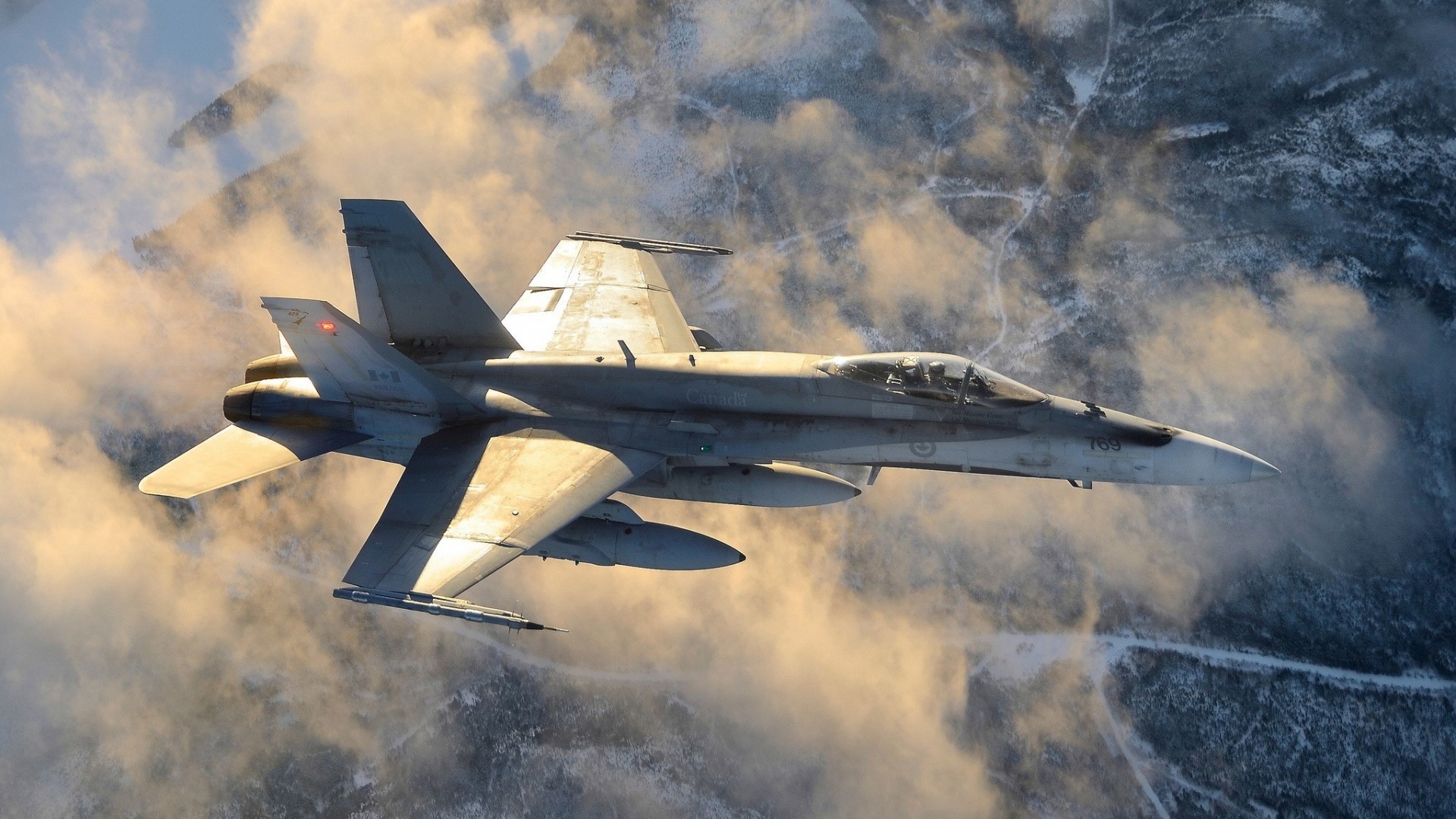 Royal Canadian Air Force CF-18 Hornet flying over snowy mountains HD Wallpaper