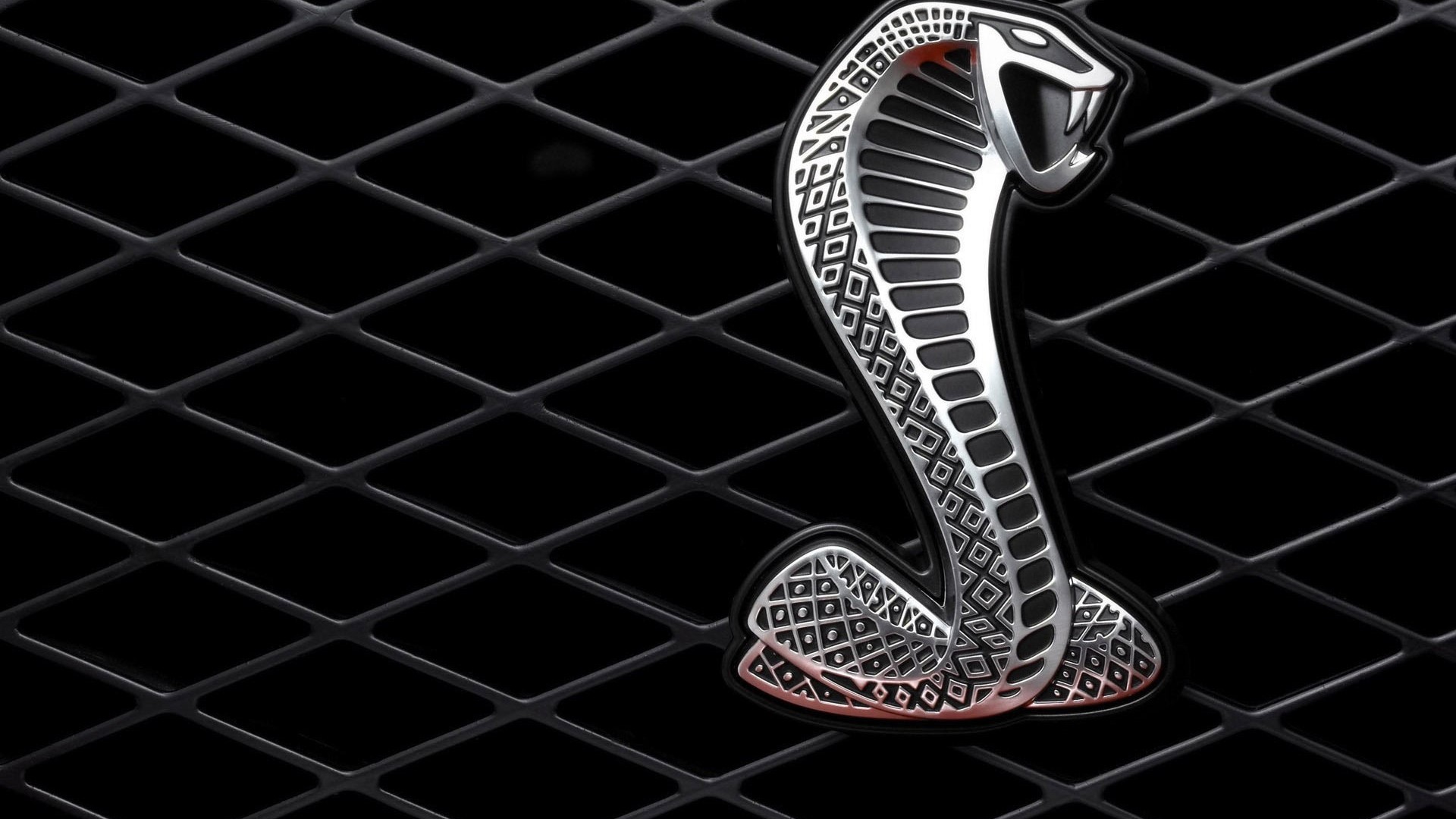 Ford Mustang Cobra emblem on a black grille HD Wallpaper