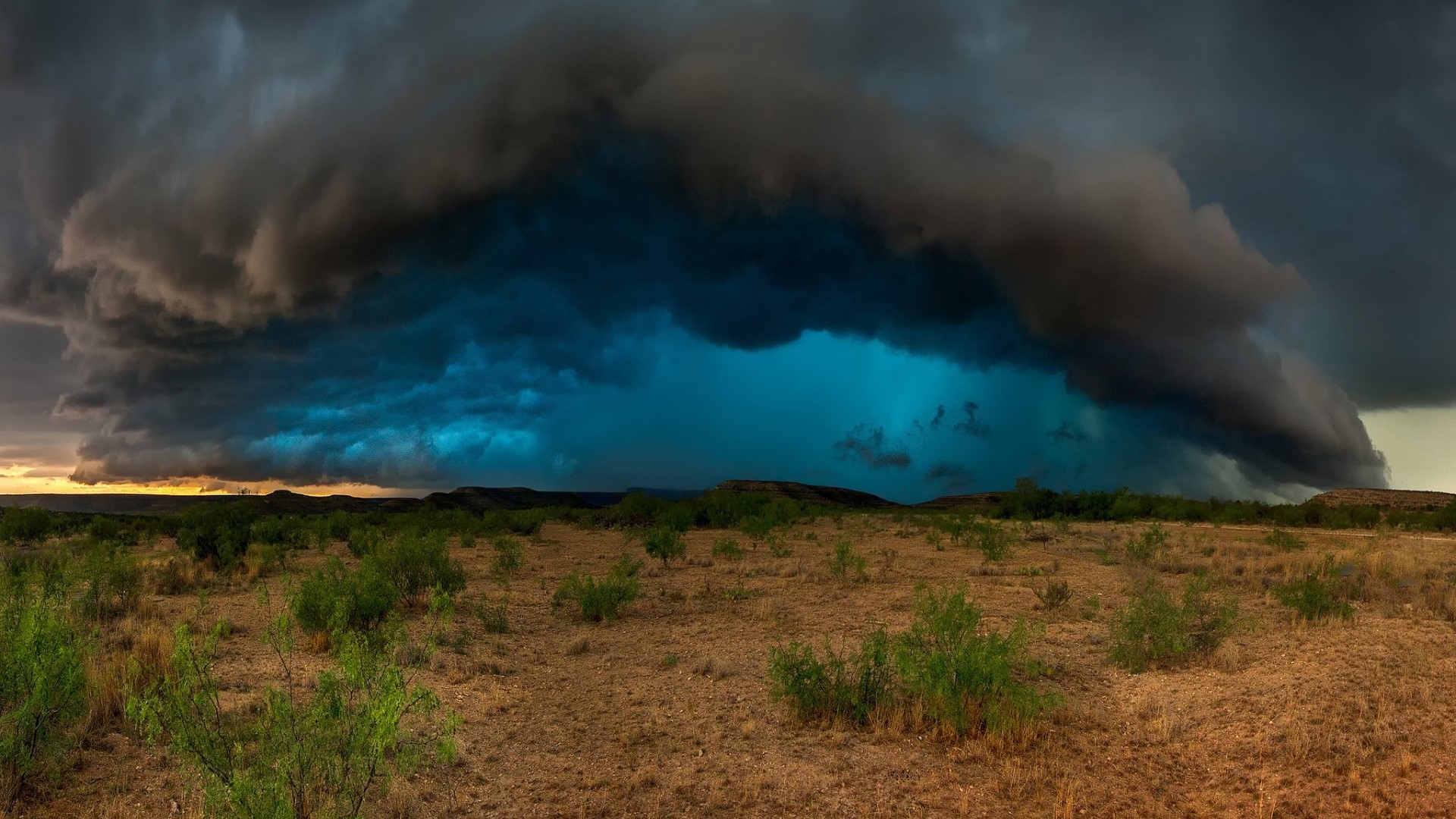 Massive storm clouds over a dry landscape HD Wallpaper