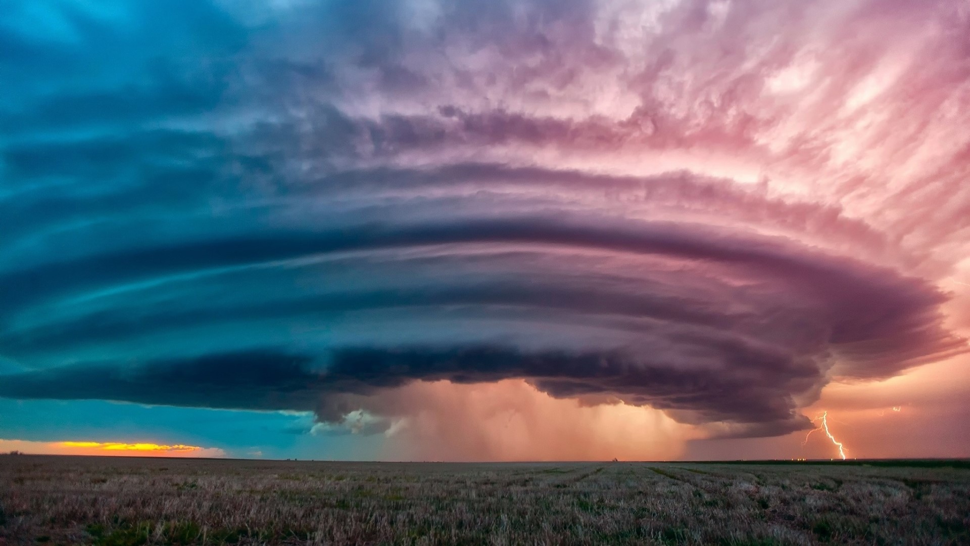 Storm clouds with lightning over a field HD Wallpaper