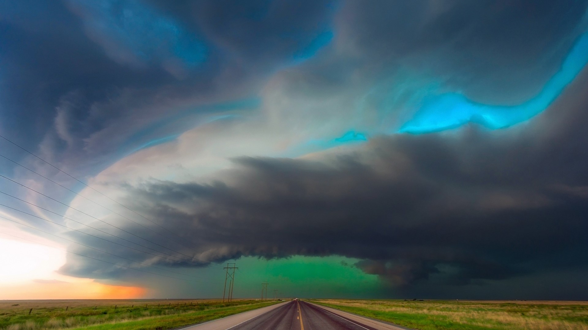 Stormy sky over a road in a field HD Wallpaper