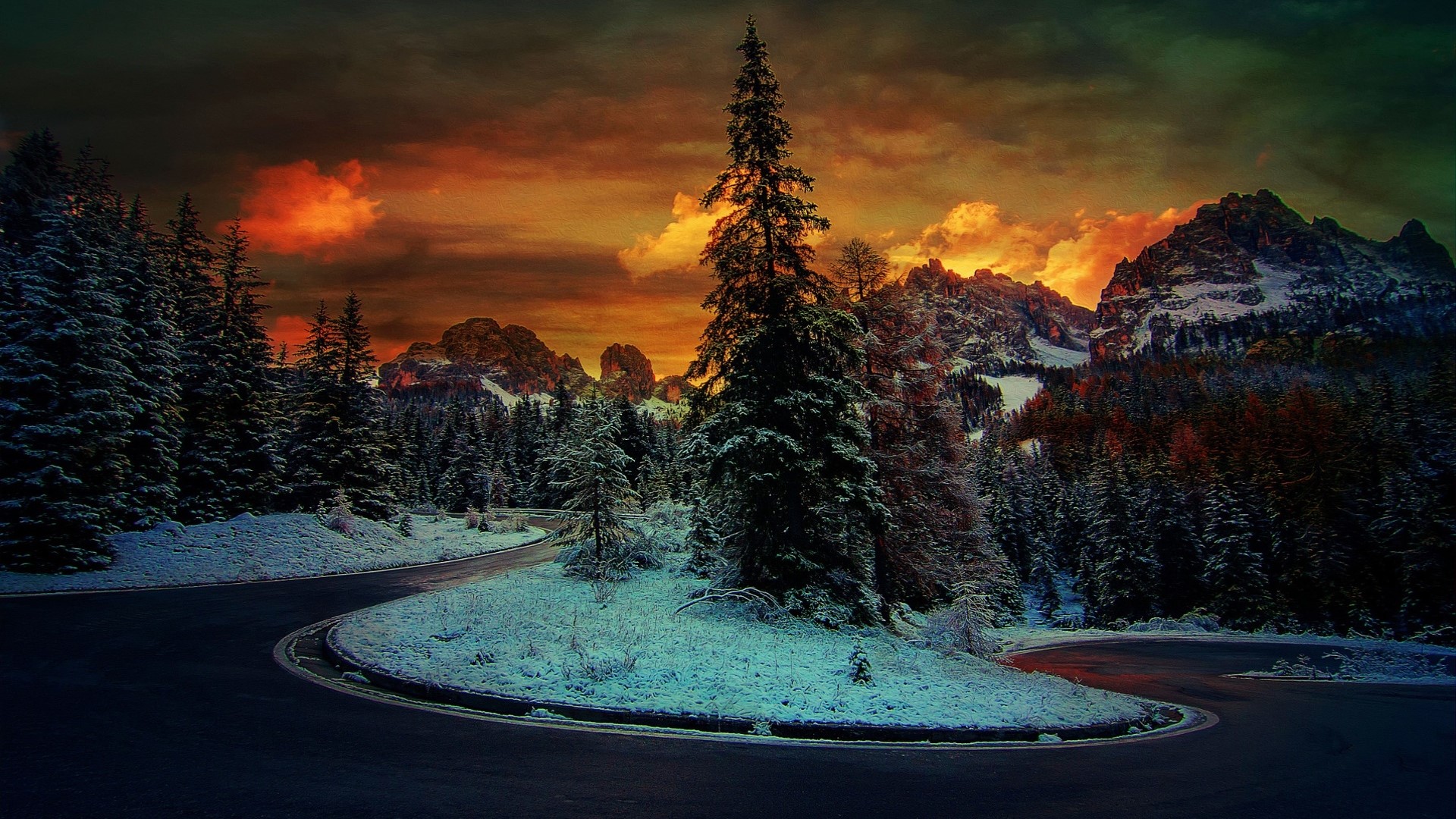 Winding mountain road through snowy forest at sunset HD Wallpaper