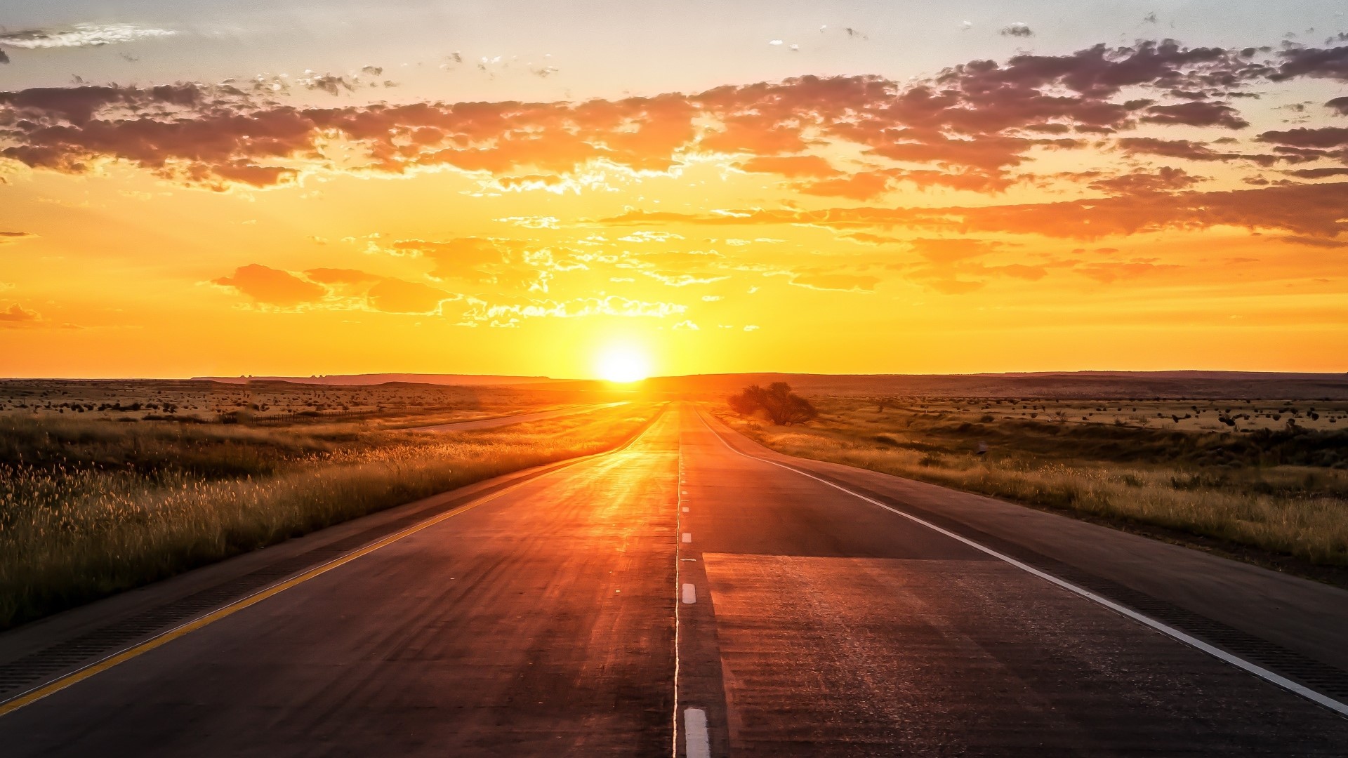 Sunset over a road in a vast landscape HD Wallpaper