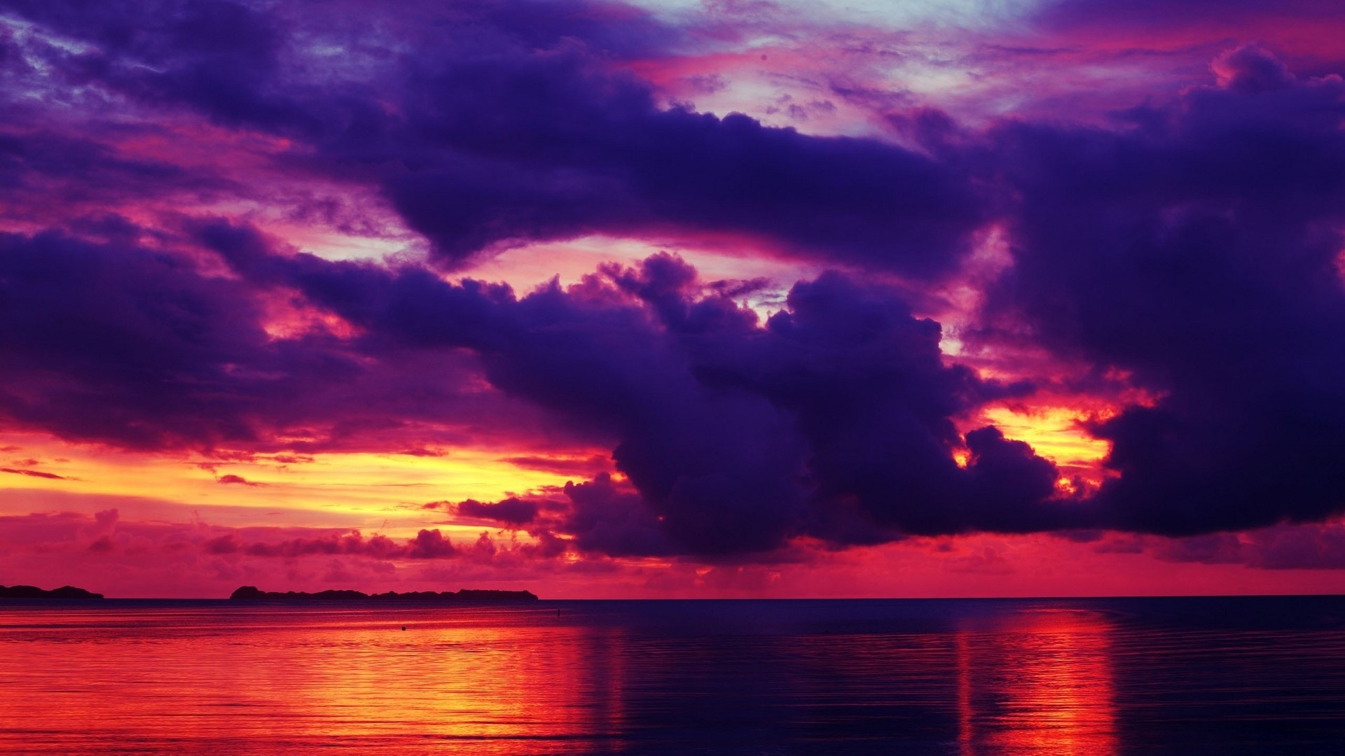 Dramatic sunset over the ocean with purple clouds HD Wallpaper