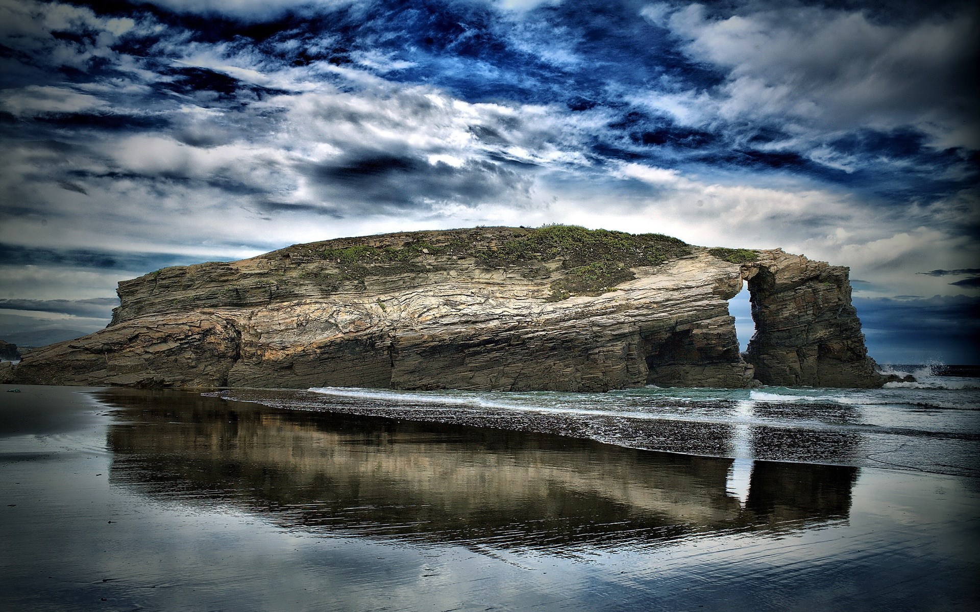 Rock Archway on a Beach with Dramatic Clouds HD Wallpaper