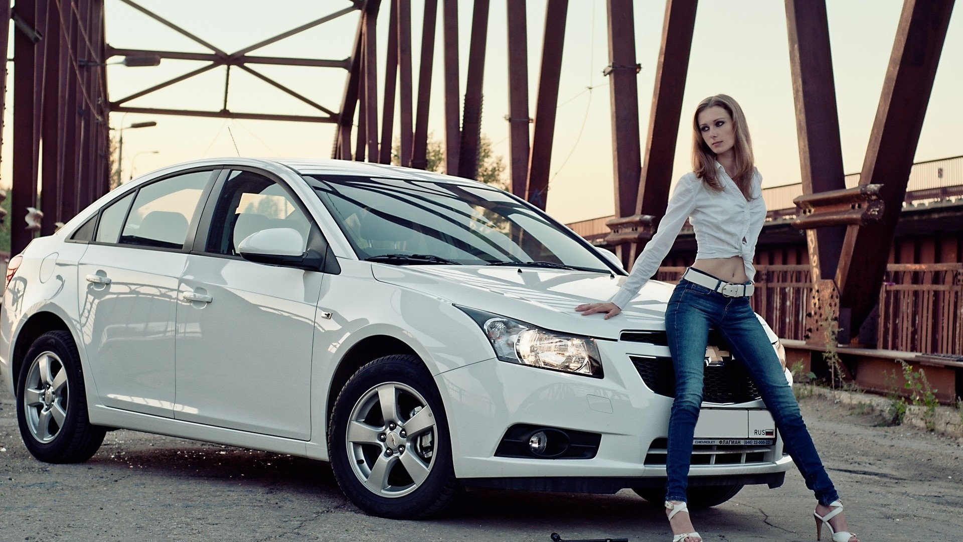 Woman posing with a white Chevrolet Cruze HD Wallpaper