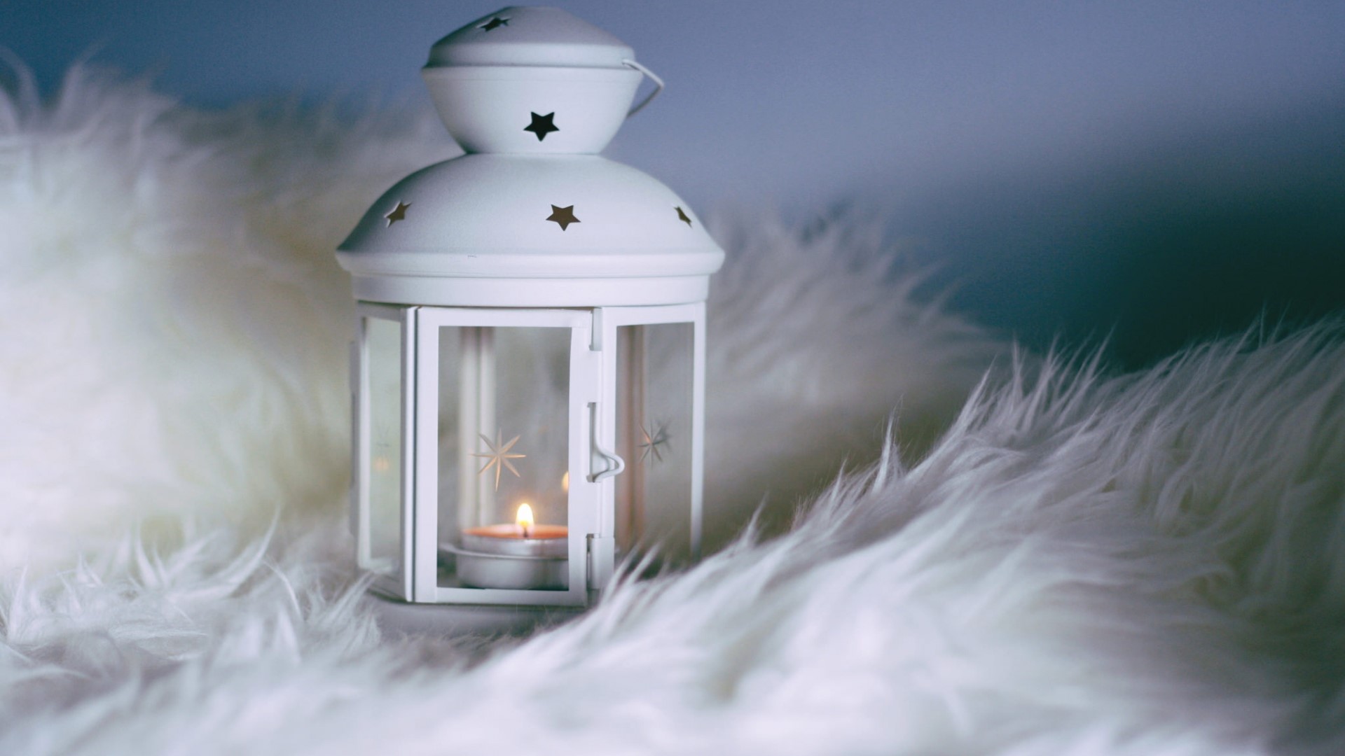 White lantern with lit candle on fluffy rug HD Wallpaper