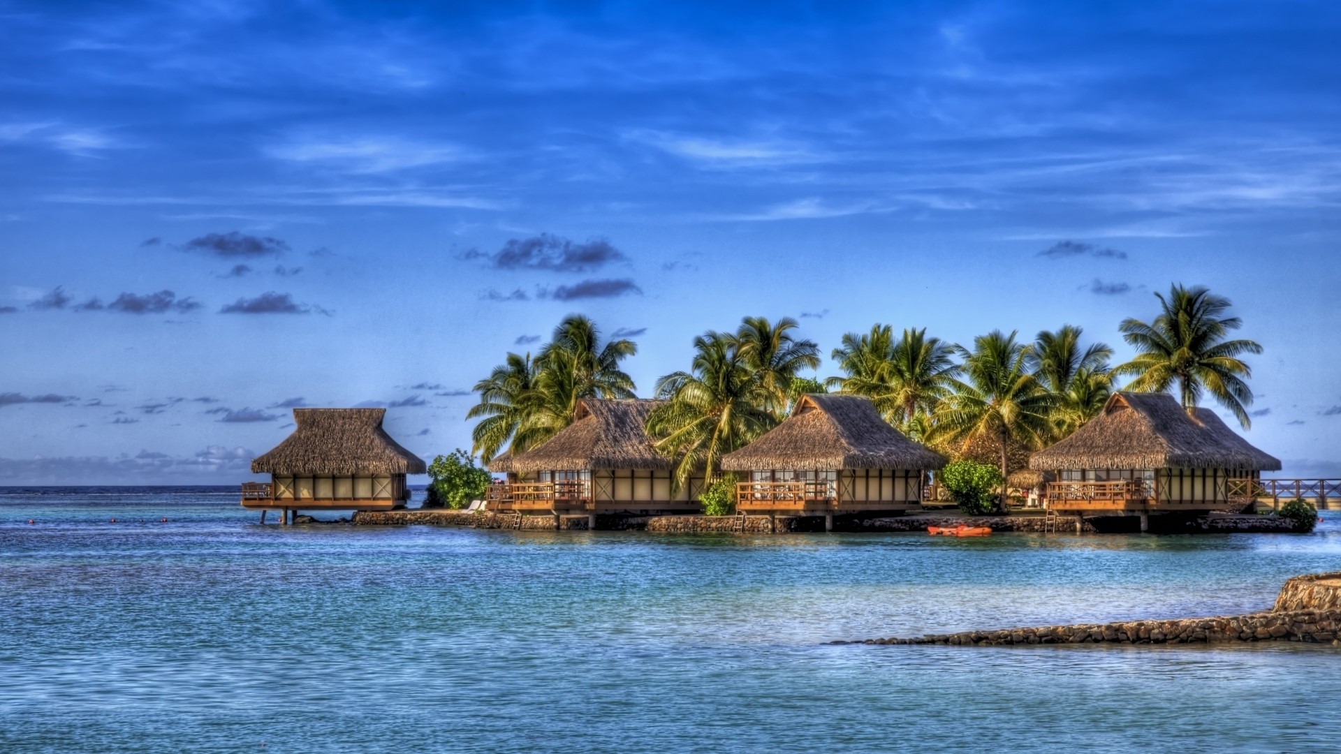 Bungalows on the water with palm trees HD Wallpaper