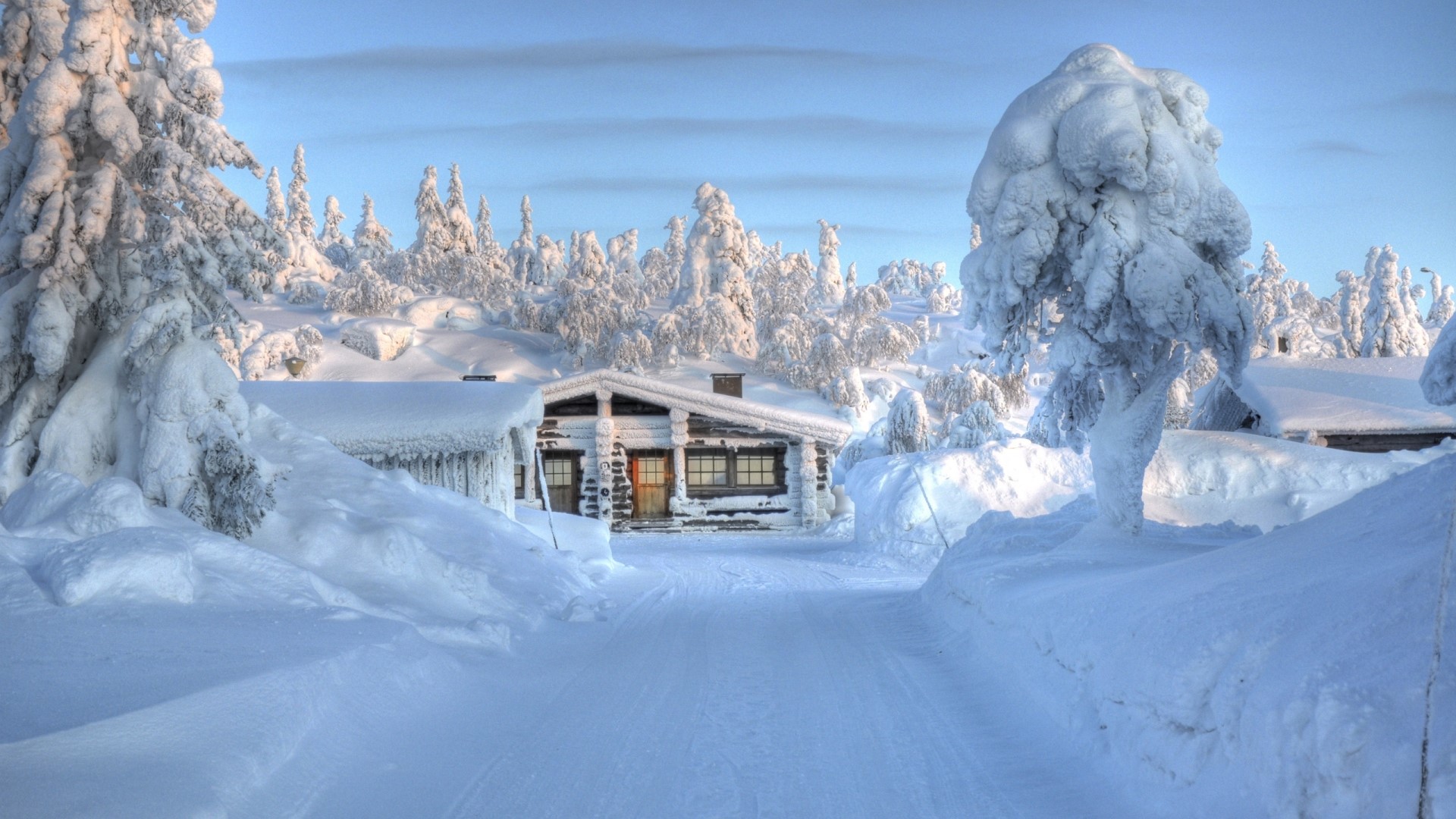 Snowy road leading to a log cabin in winter HD Wallpaper