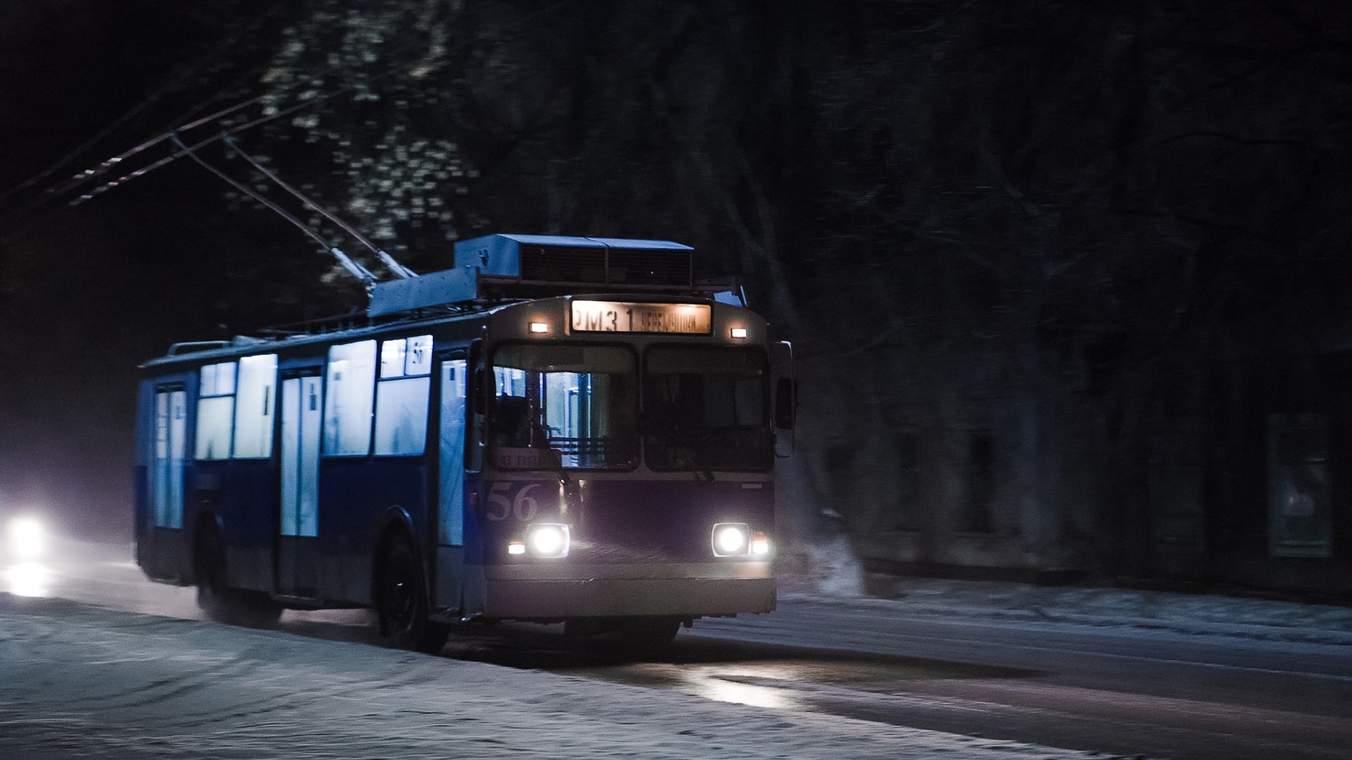 Trolleybus on a snowy road at night HD Wallpaper