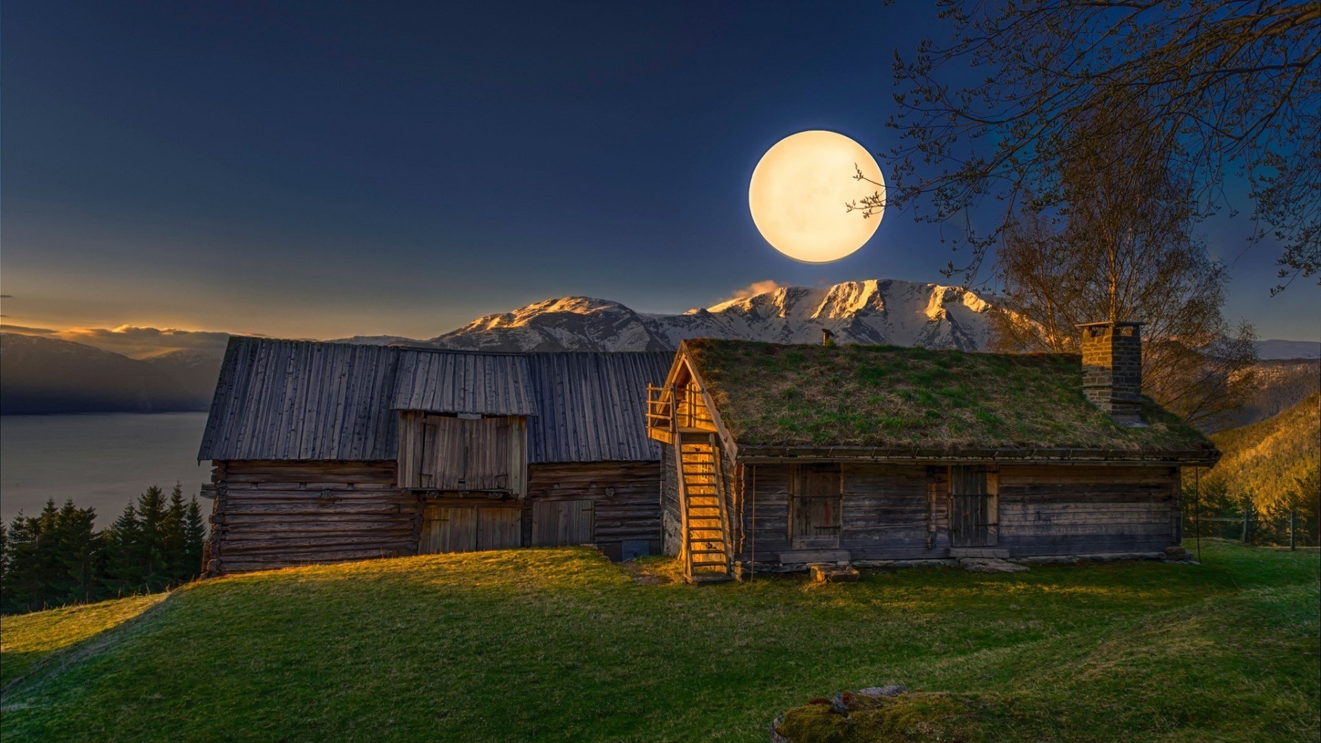 Wooden cabins under a large full moon and mountains HD Wallpaper