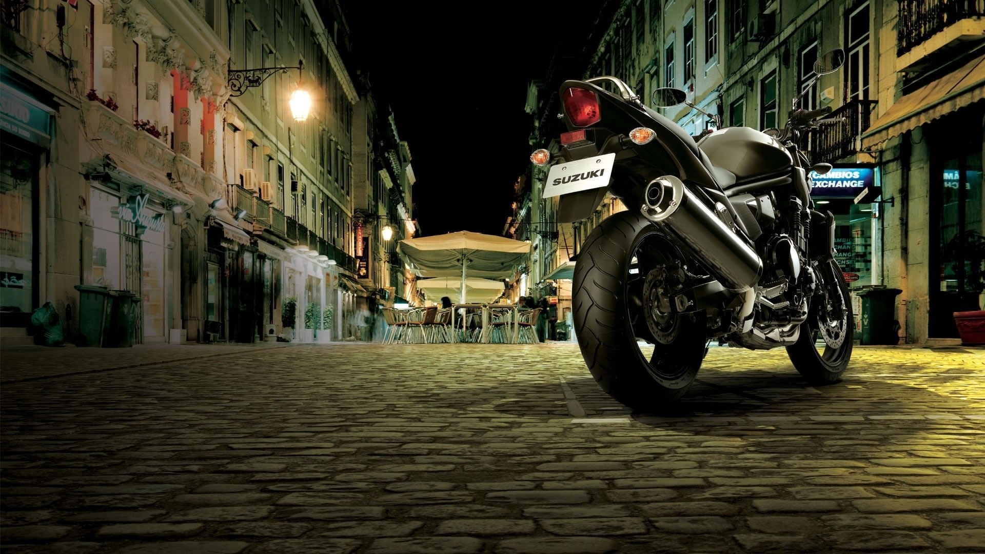 Suzuki Bandit motorcycle parked on cobblestone street at night HD Wallpaper