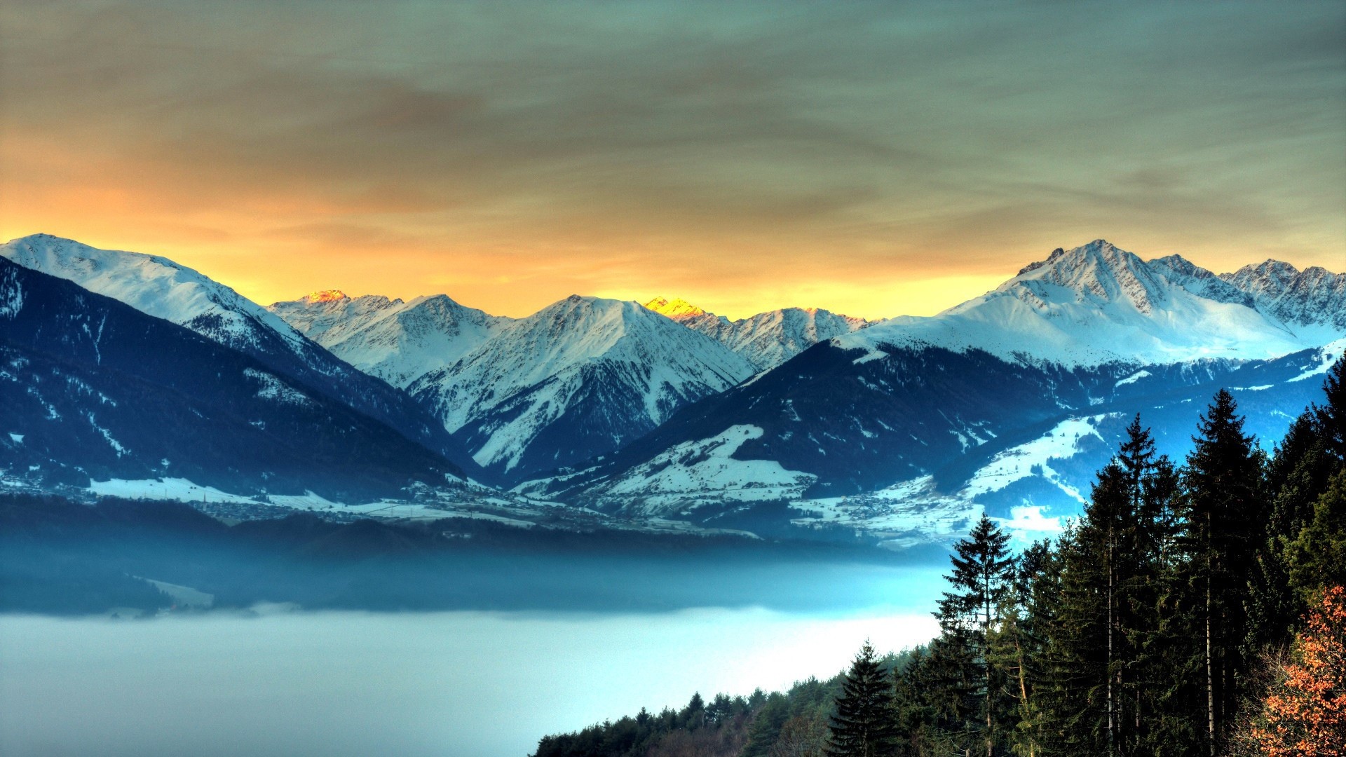 Snow covered mountains at sunset with fog HD Wallpaper