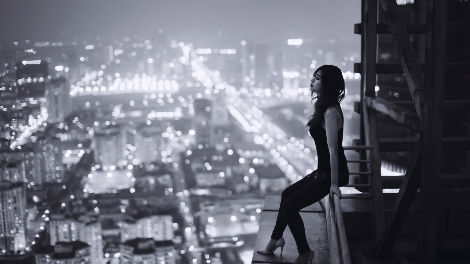 Woman on a Ledge Overlooking Cityscape HD Wallpaper