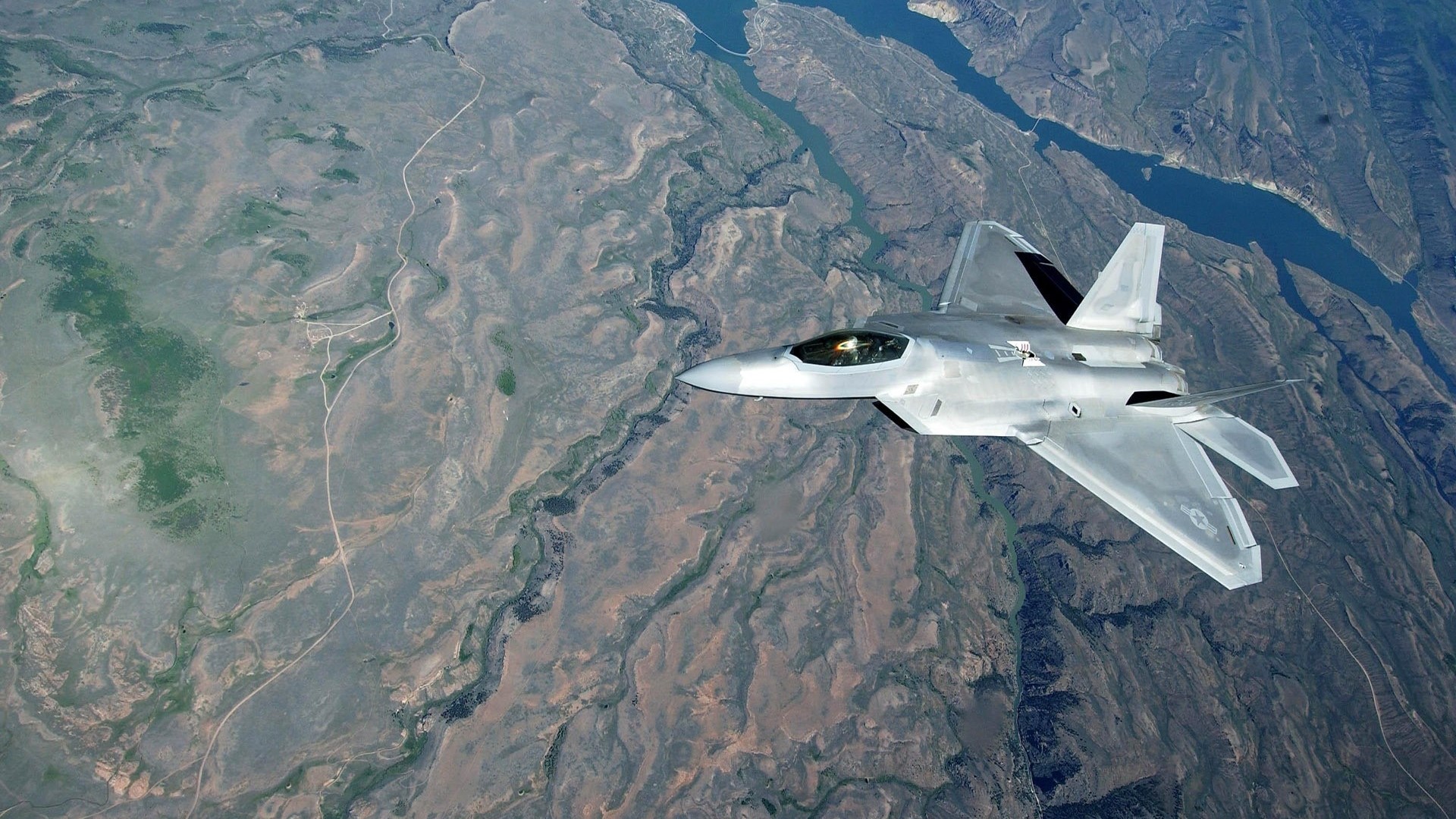 F-22 Raptor flying over a canyon HD Wallpaper