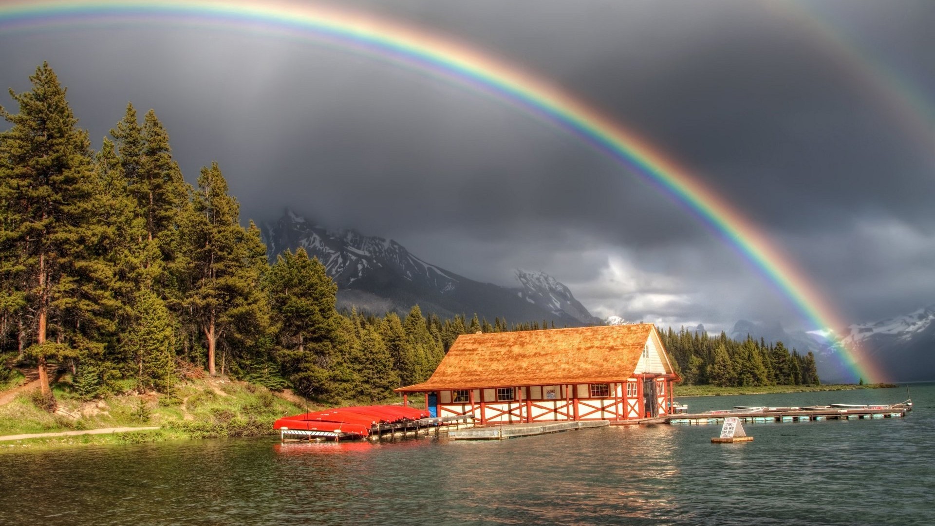 Double rainbow over a lake house with canoes HD Wallpaper