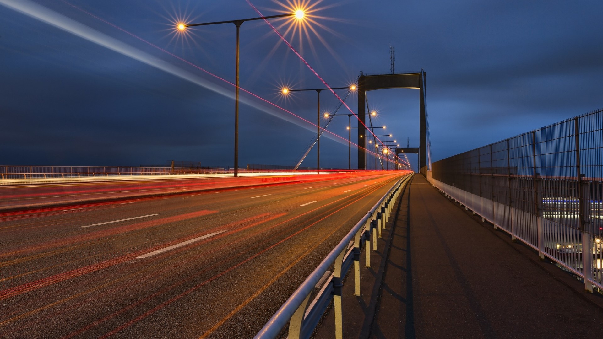 Long exposure of a bridge at night with light trails HD Wallpaper