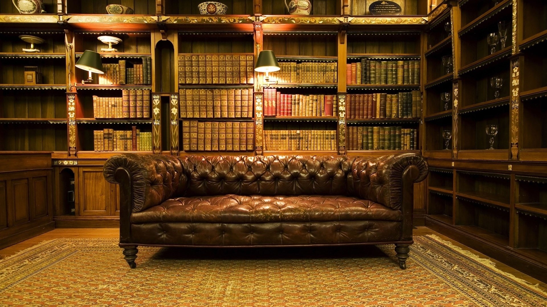 Leather sofa in a library with bookshelves HD Wallpaper