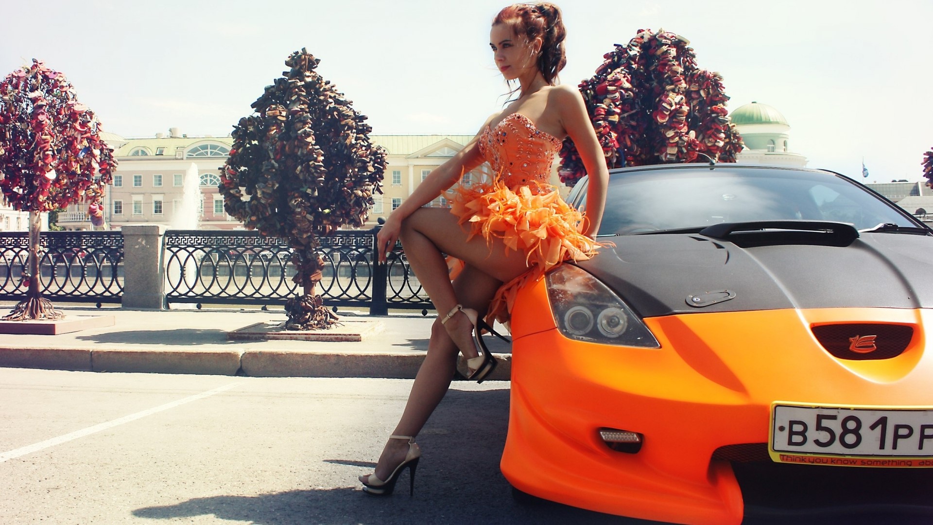 Woman in orange dress posing with orange sports car HD Wallpaper
