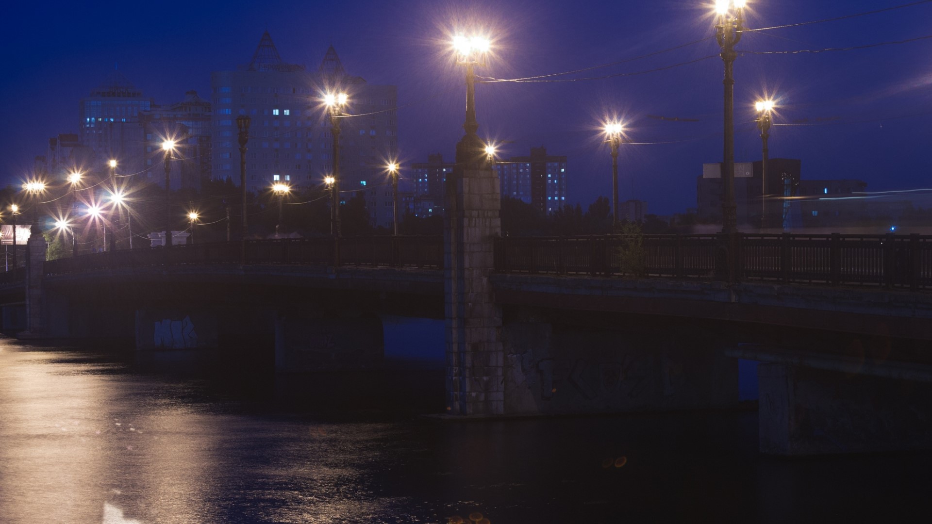 City bridge at night with streetlights and buildings HD Wallpaper