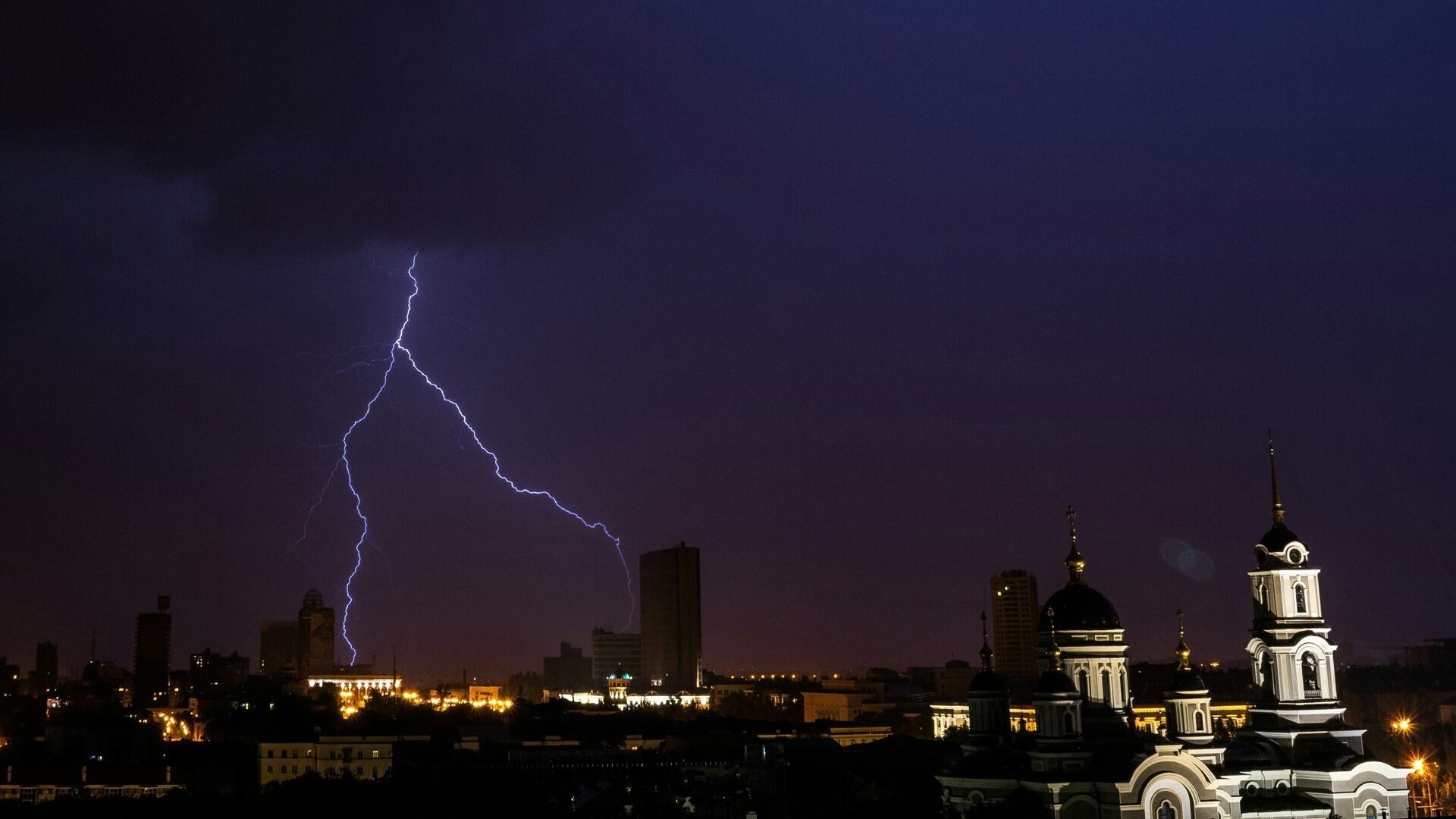 Lightning strikes over Donetsk city skyline at night HD Wallpaper